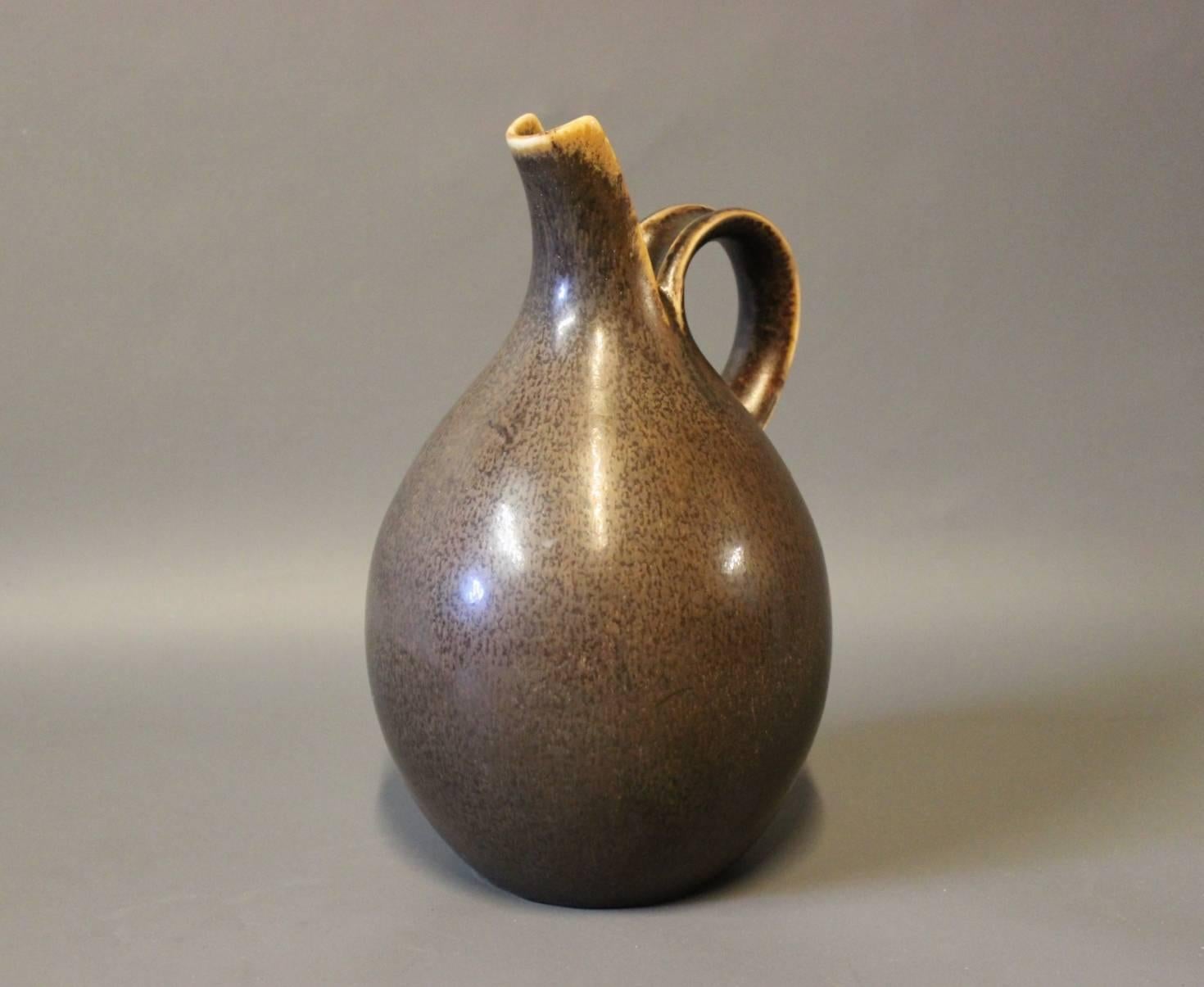 Pitcher with dark brown glaze designed by Eva Stæhr Nielsen for Saxbo. The jug is numbered 64 and is in great vintage condition.