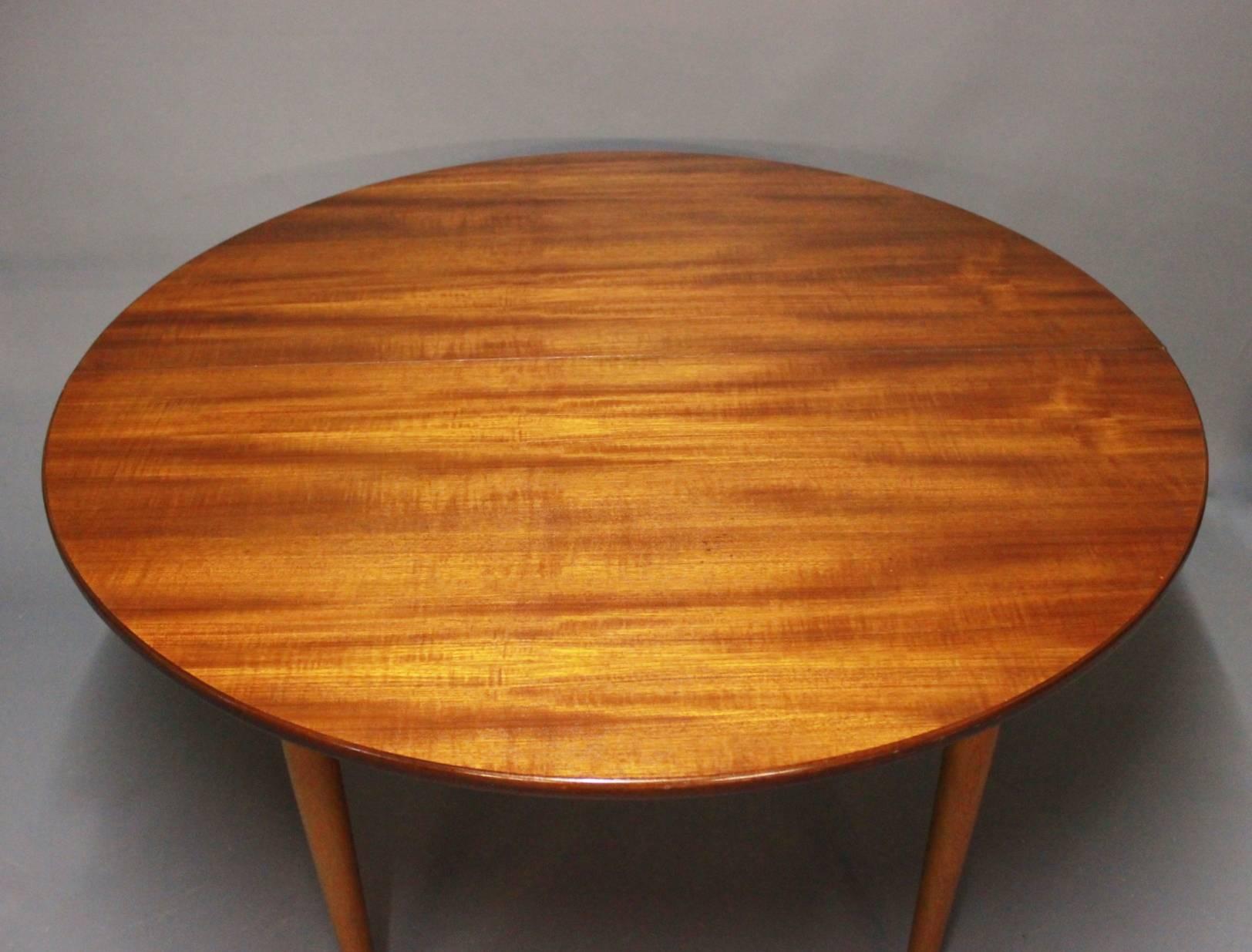Round dining table with extensions in teak and legs of oak designed by Hans J. Wegner and from the 1960s. The table is in great vintage condition.