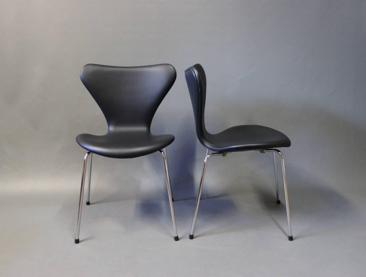 A pair of seven chairs, model 3107, designed by Arne Jacobsen and manufactured by Fritz Hansen in 1967. The chairs have recently been upholstered in Classic black leather.