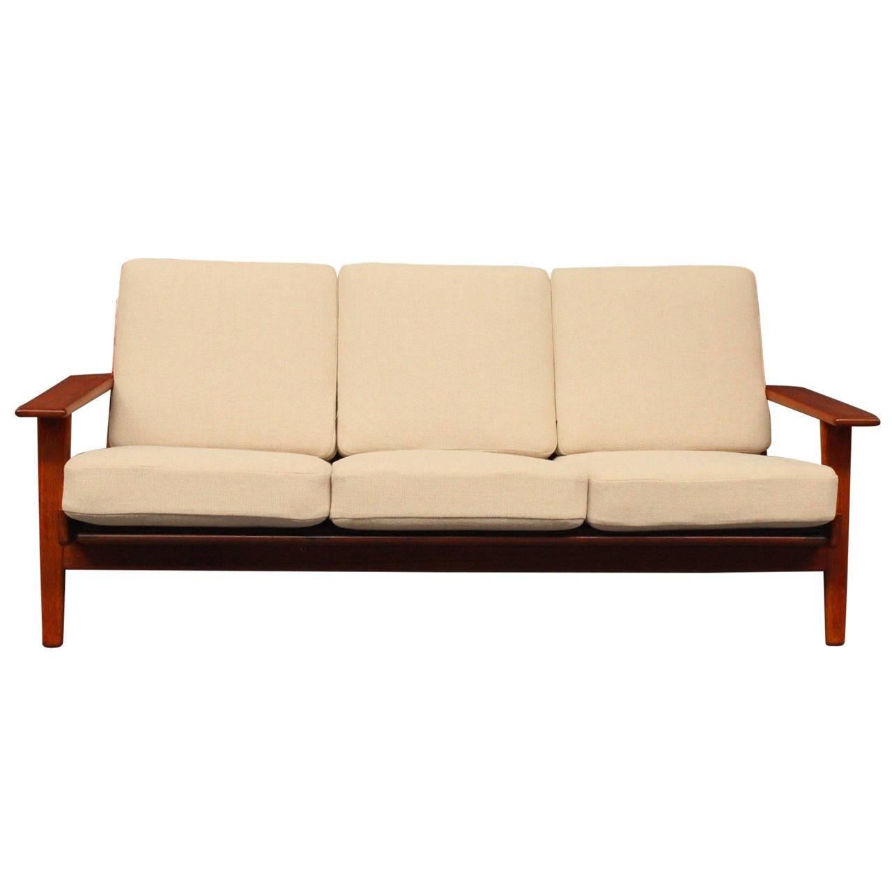 The three-seater sofa in teak, model GE 290, is an emblem of Danish modernism and functionality. Designed by Hans J. Wegner, a prominent figure in Danish furniture design, this sofa reflects his characteristic approach to simplicity and