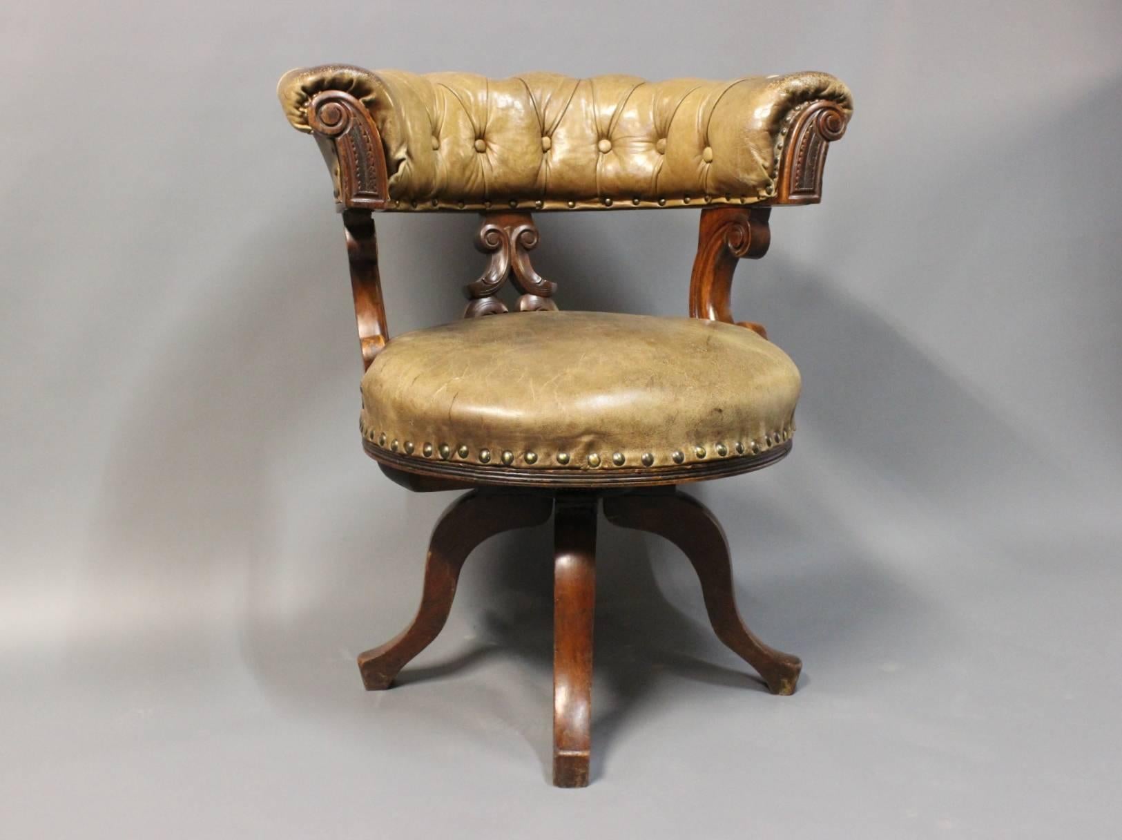 Office chair in mahogany and in golden brown original patinated leather. The chair has been upholstered with brass nails and is rotatable. The chair is from England and circa 1880.