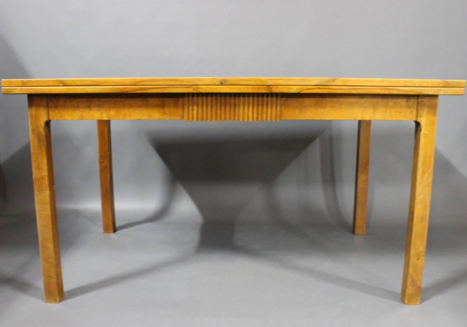La table coulissante en noyer, fabriquée par un maître charpentier danois et représentative du design danois, date des années 1940 et témoigne d'une époque caractérisée par le savoir-faire artisanal et l'élégance intemporelle.

Les tons chauds et le