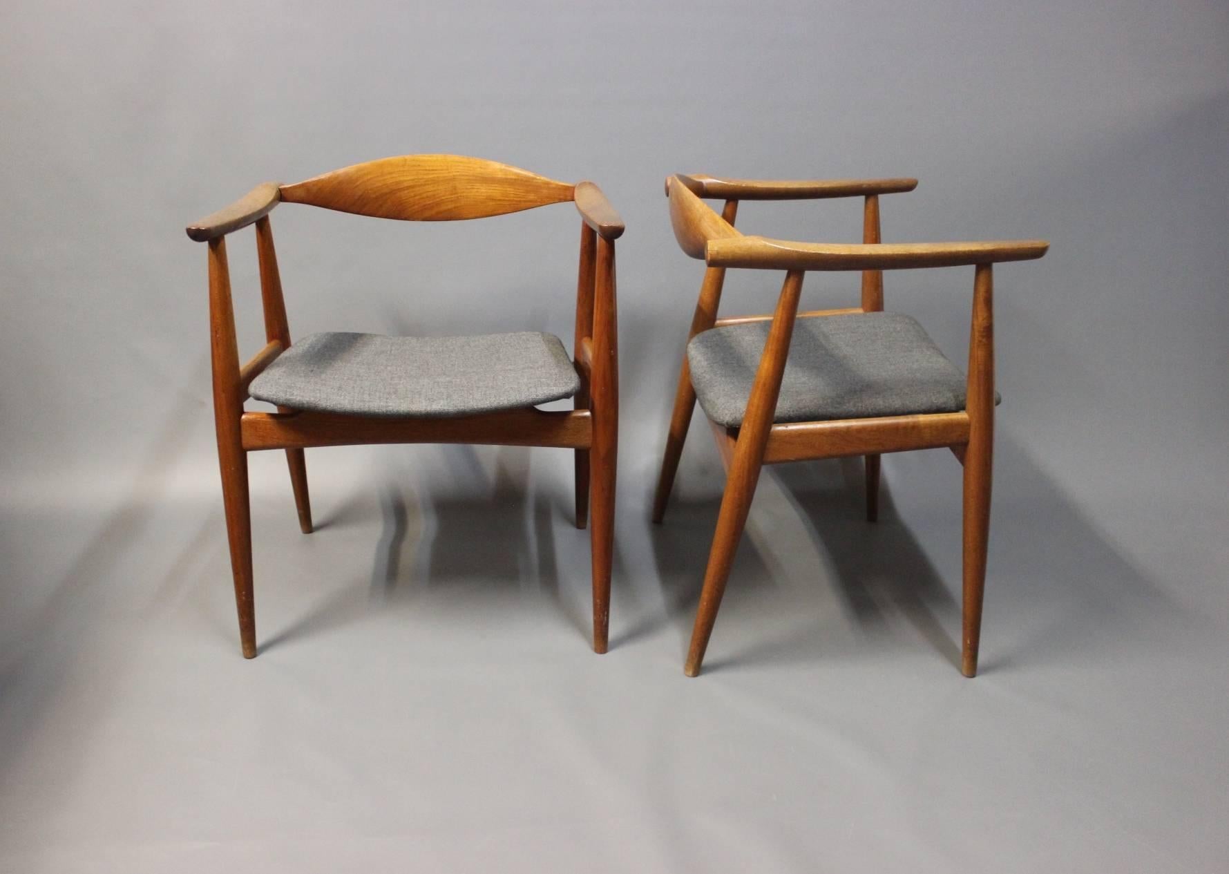 A pair of dining room chairs, model CH-35, designed by Hans J. Wegner in 1959 and manufactured by Carl Hansen & Søn in the 1960s. The chairs are in teak and upholstered in grey wool.