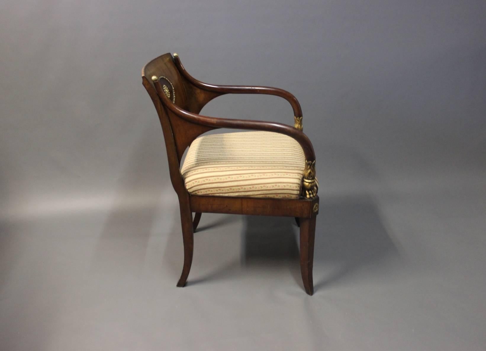 Armchair in polished mahogany, inlaid fruitwood and decorated with brass and leaf gold. The chair was made in Germany in 1830 and upholstered in light fabric.