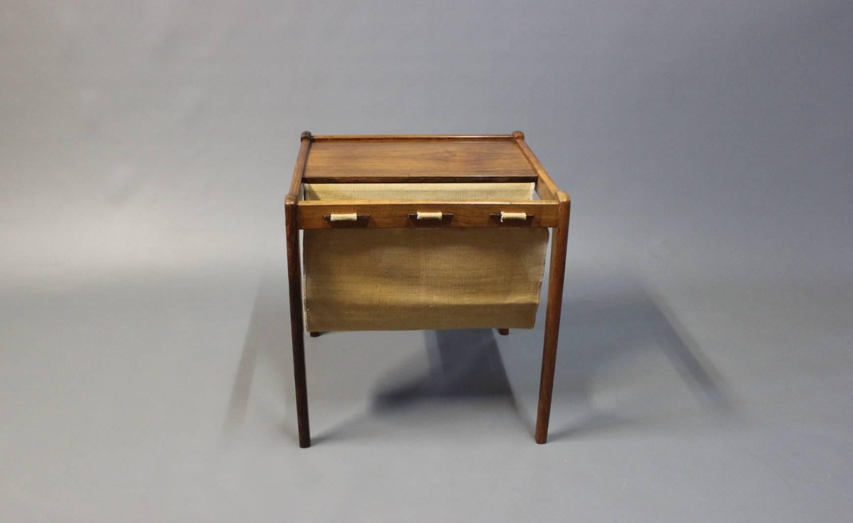 Small newspaper holder and/or lamp table in rosewood. The table is of Danish design from the 1960s made by an unknown Danish cabinetmaker.