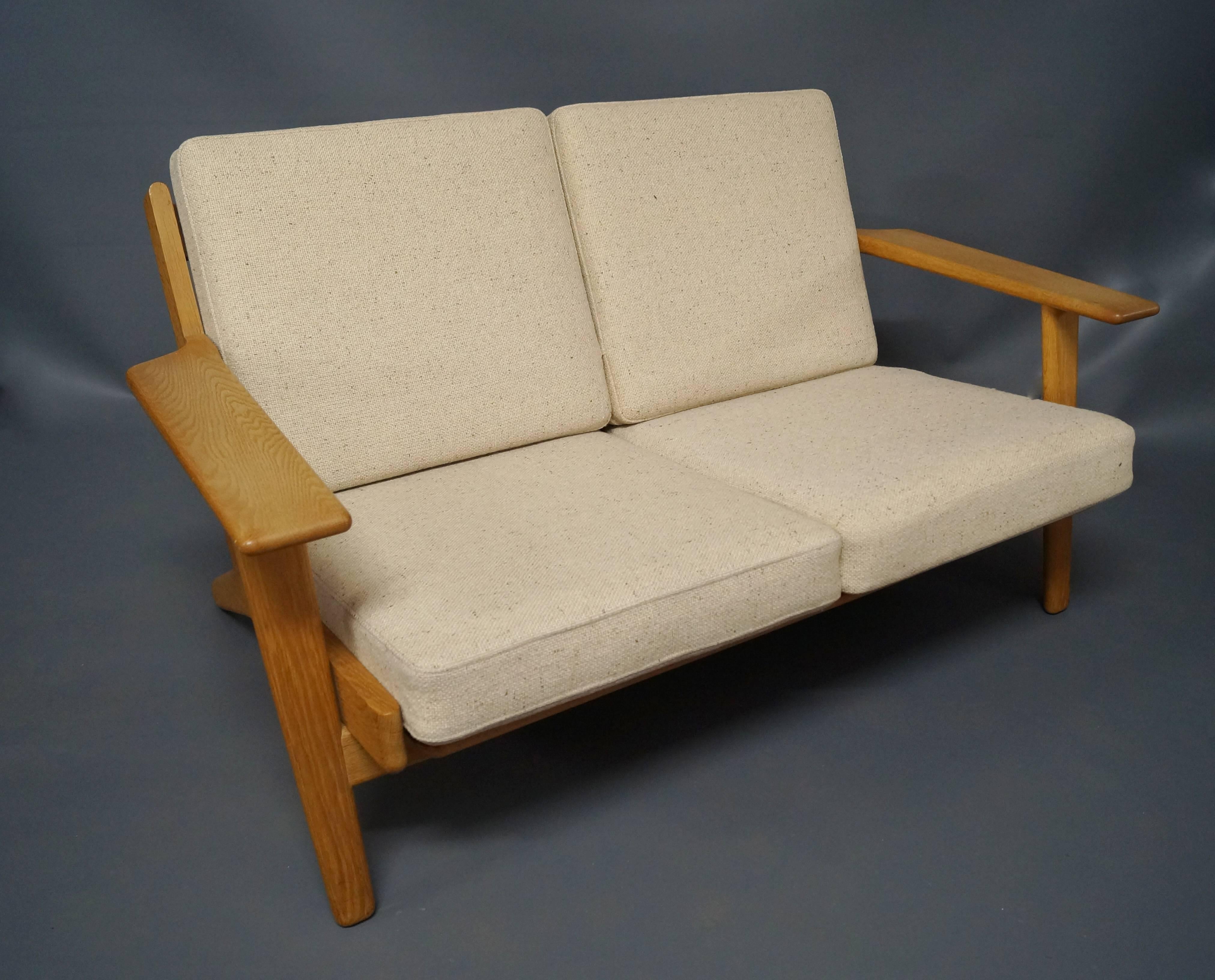 GE 290 two-person sofa designed by Hans J. Wegner in 1953 and manufactured by GETAMA in the 1960s. The sofa is in oak and light Hallingdal wool.
 