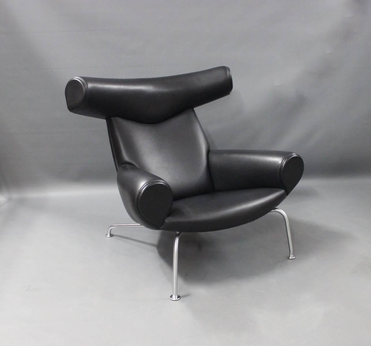 The Ox chair, model EJ 100 and stool model EJ 100-F, upholstered in black leather, designed by Hans J. Wegner in the 1960s and manufactured at Erik Jørgensen furniture factory the 20th of January 2008. The chair and stool can be purchased