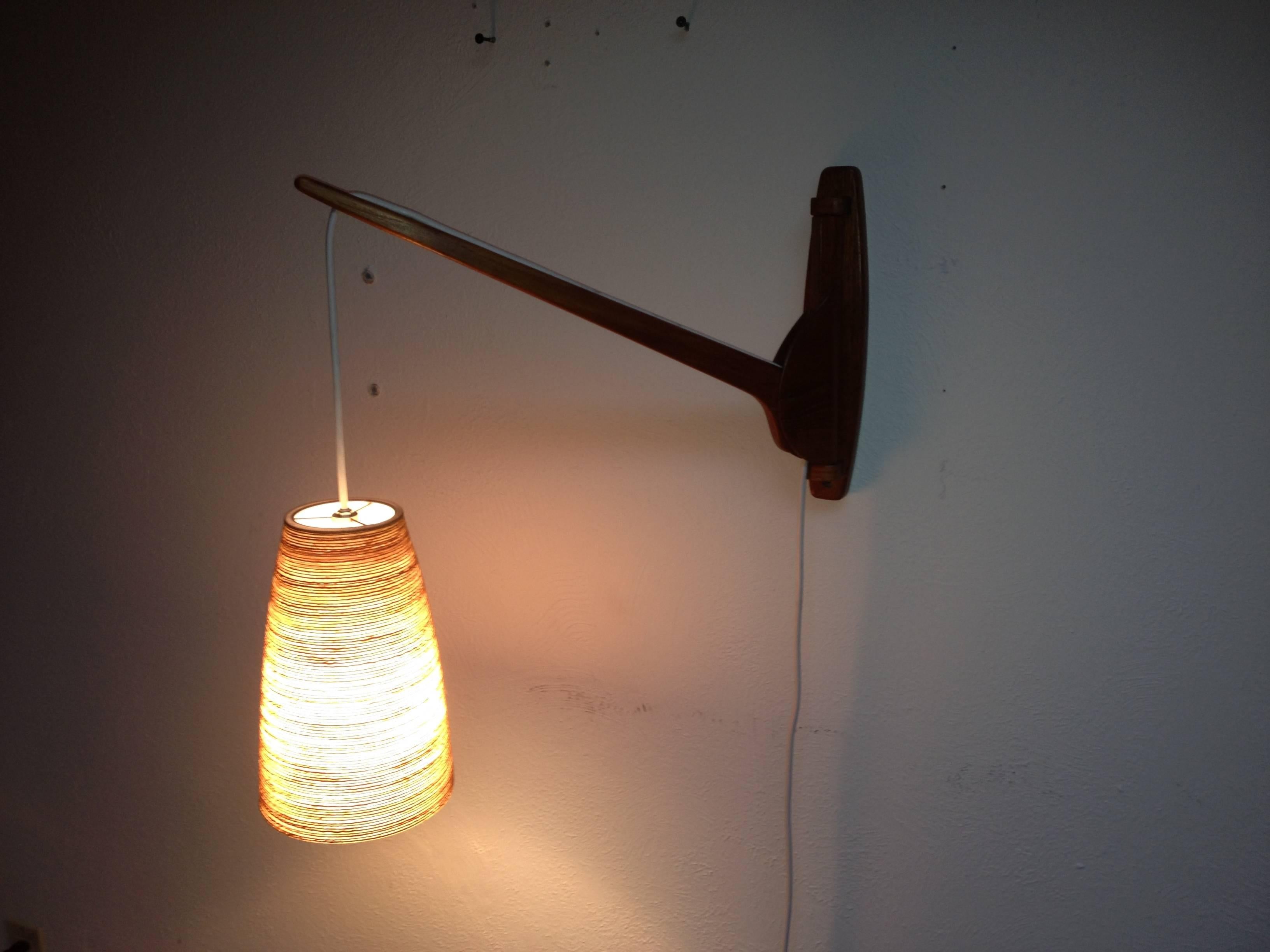 Gorgeous 1960's Teak armed wall light with an original Vintage Lotte & Gunnar Bostlund fiberglass shade w/spun yarn.  Perfect for beside your favorite reading chair or use as a bed side lamp - the arm sways side to side for more direct light. 
 The