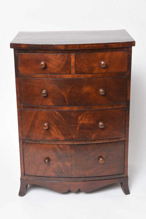 The bow front chest is a fine example with an elaborate apron and graceful proportions bearing an old label from Stair & Co.