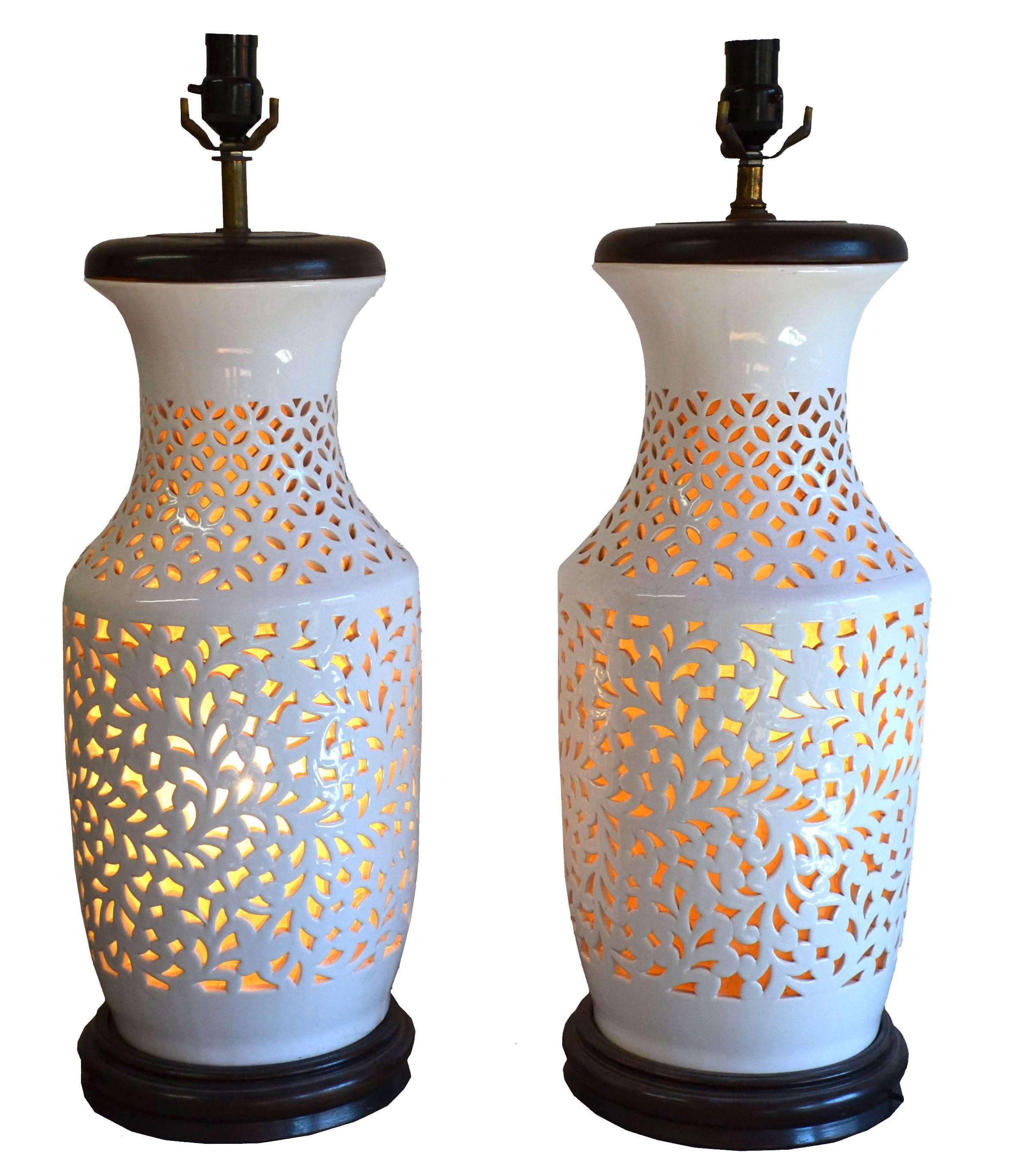 Beautiful and chic Hollywood Regency Asian-inspired Blanc de Chine table lamps, circa 1950 has interior light (with separate switch) for added drama. These incredible reticulated table lamps are mounted conforming wooden base. Sold without shades.