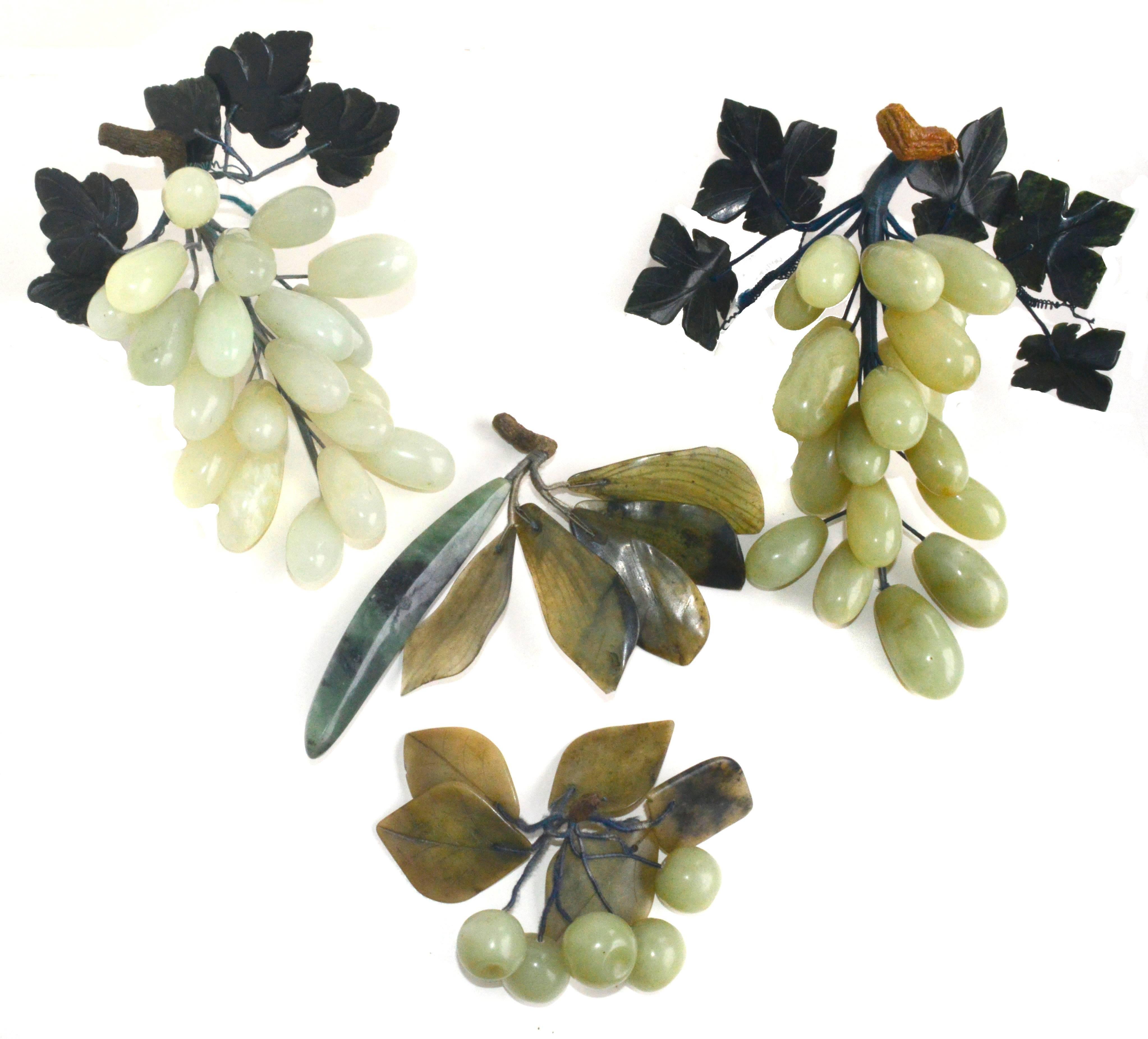 Grouping of three bunches of carved semi-precious, stone grapes: One done in rose quartz, two in jade with jade leaves and wood stems. Vintage, handmade in China. Approximate size of each bunch, 9