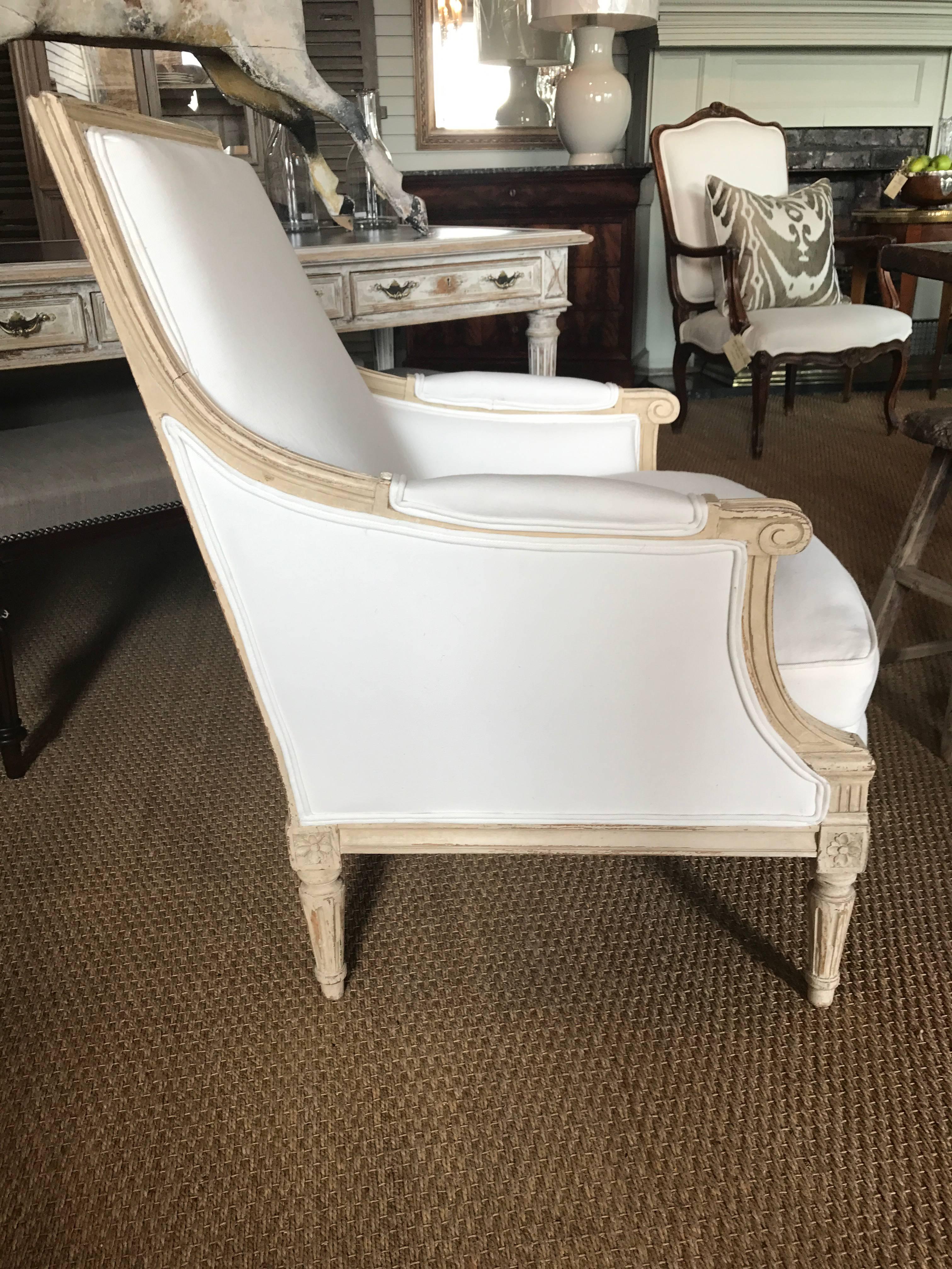 Pair of bergeres with pretty carved frame finished in soft cream. Freshly reupholstered.
