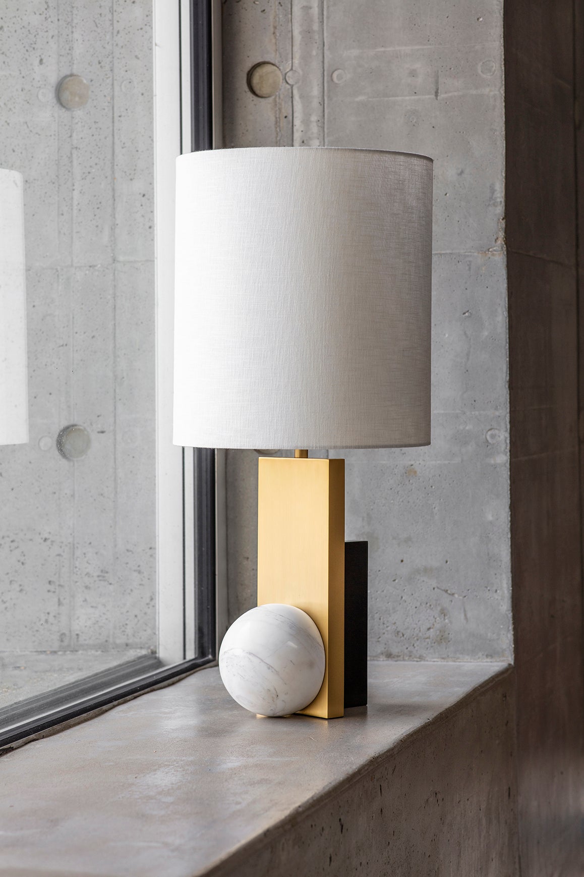 Triadic table lamp by Square in Circle, 2022
Dimensions: H 72 cm x Base W 23 x D 15 cm
Shade: H 35 x D 35 cm
Materials: Brushed brass, white marble, dark bronze, white cotton shade

The Triadic Table Lamp uses a simple combination of geometry.