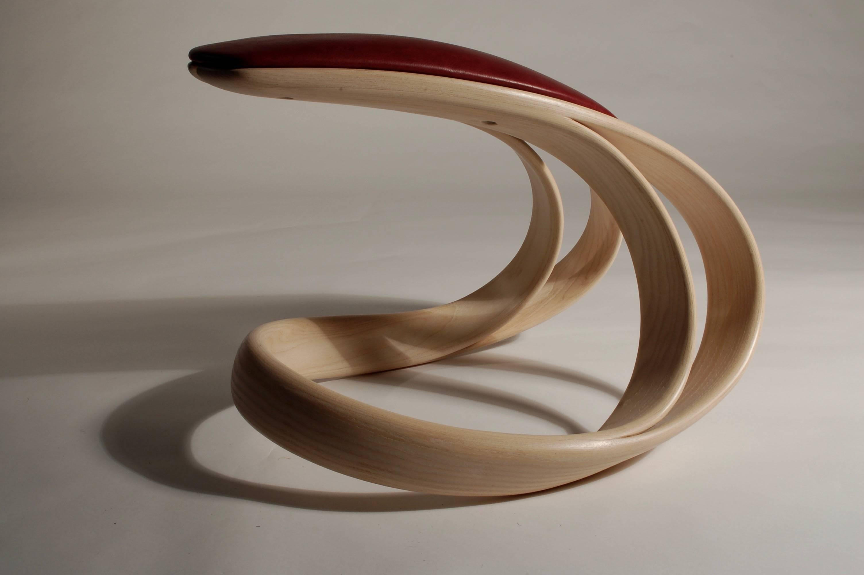 Jan Waterson. 
Title: Velo Rocking Stool. 
Materials - European ash, leather.
Dimensions: 43.5 x 47 x 59 cm.

The bicycle is an object in which the user can feel a seamless relationship to and subsequently the road. This relationship between