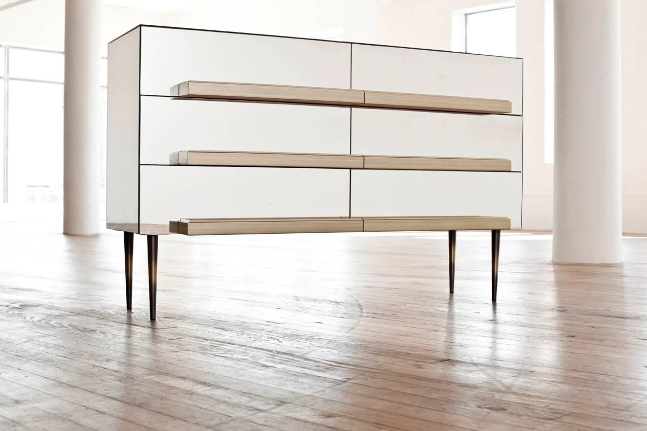 Illusion credenza.
IGL-01 Illusion Collection.
Design by Luis Pons.
Six drawers credenza featuring a dark walnut finish interior.
Antique bronze steel legs. Mirror finish with Silver Frame Handles with Gold accents. Back in Satin dark walnut