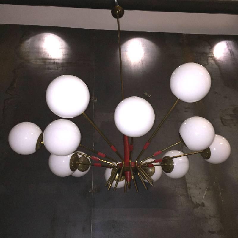Italian Mid-Century chandelier by Stilnovo. 
12 lights with E14 socket.
Very good original vintage conditions. 
Brass, lacquered metal and opaline glass. 
Diameter 100 cm, total height with rod 103 cm. 
Glasses in perfect conditions, brass with