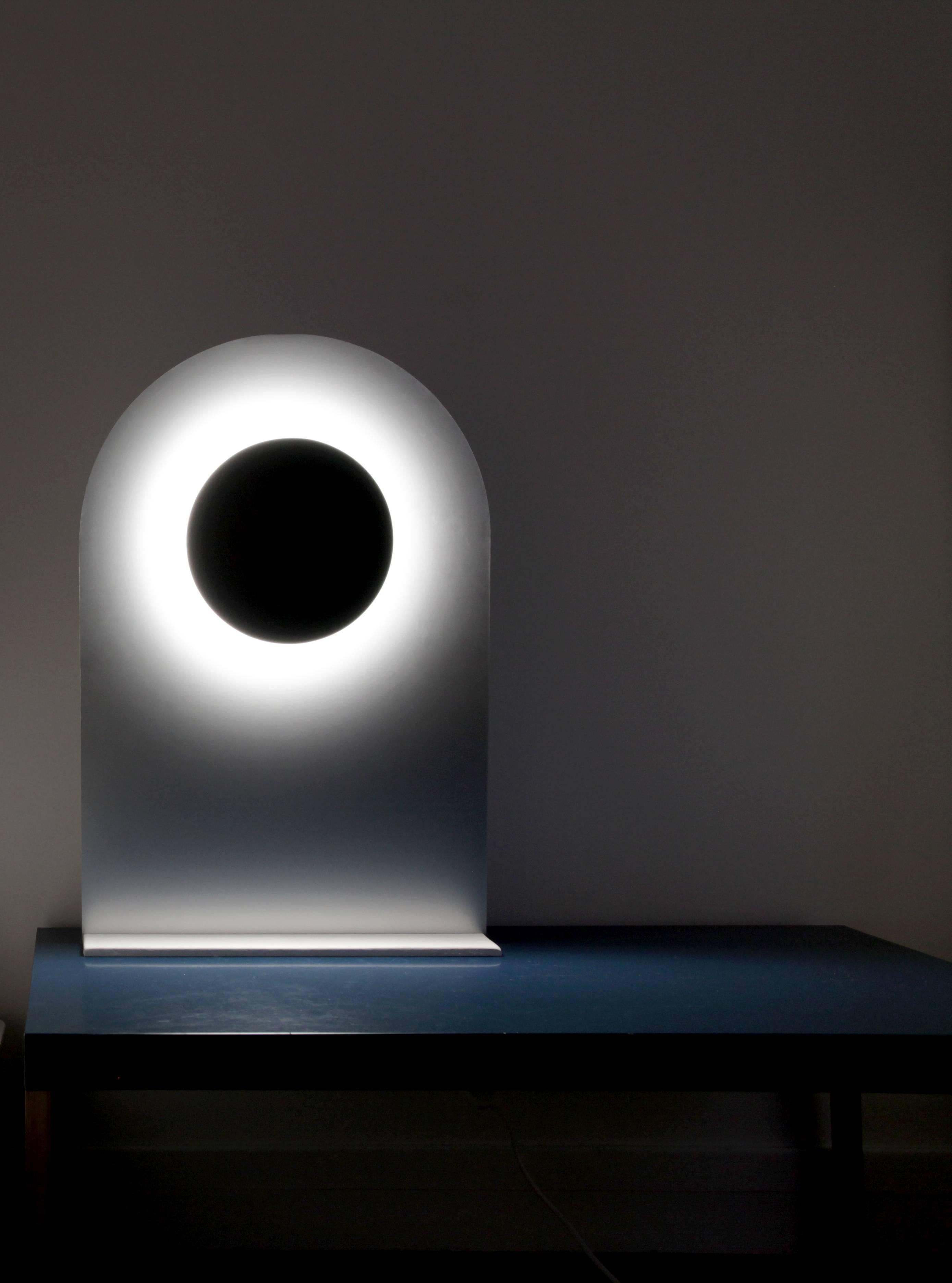 Eclipse Table Lamp by Arturo Erbsman
Handcrafted design artwork by Arturo Erbsman
Limited Edition, Signed and numbered
Dimensions: 60 x 39 x 12 cm
Materials: anodized aluminum disc, mirror, LED spotlight, wood, recomposed stone base (Corian)

All