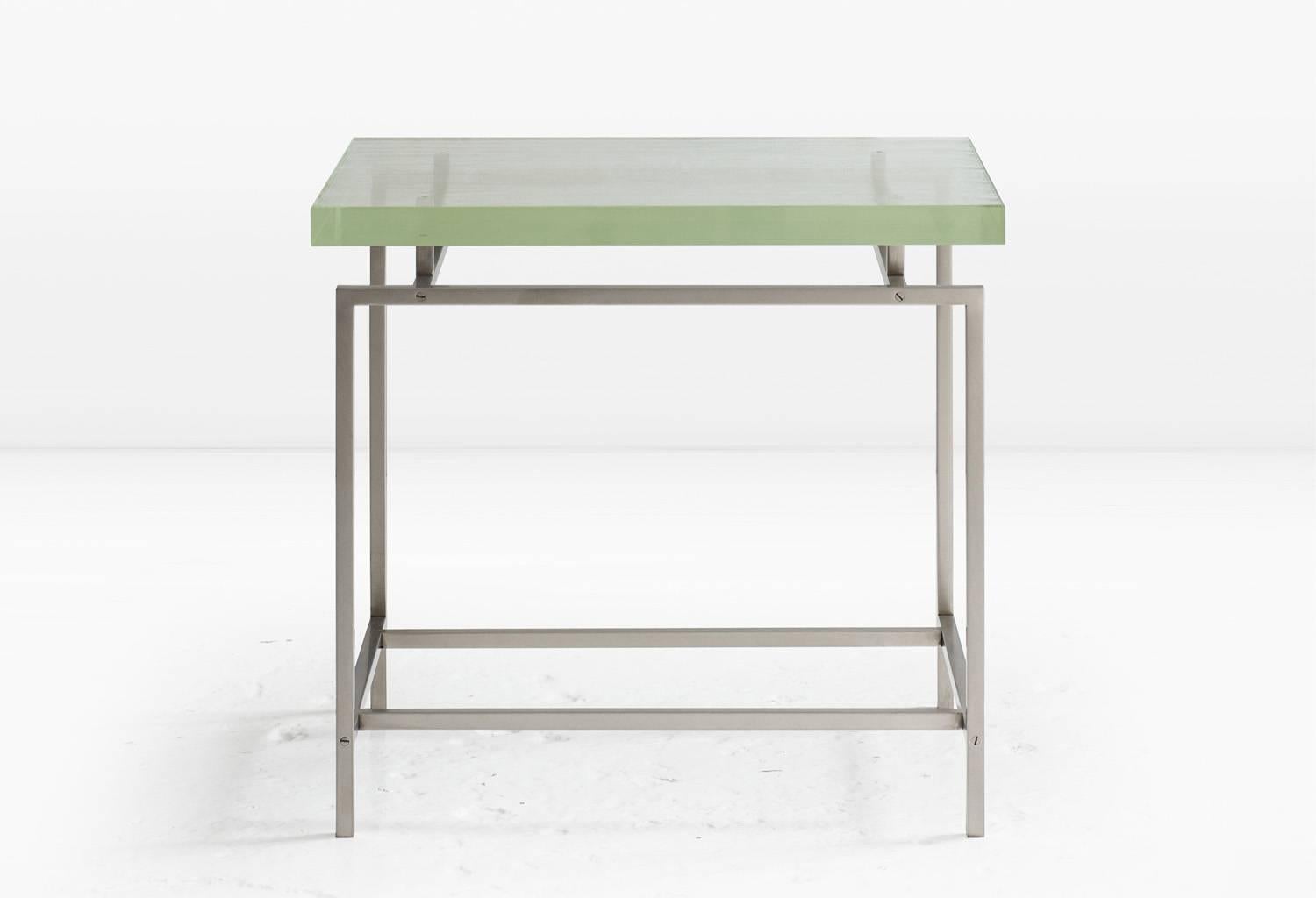 A slab of impossibly thick Borosilicate glass floats above a metal base which, rather than being welded, is fastened with delicate metal screws. Base is shown in nickel with matching screws (also available in Silicon Bronze). The top is shown with