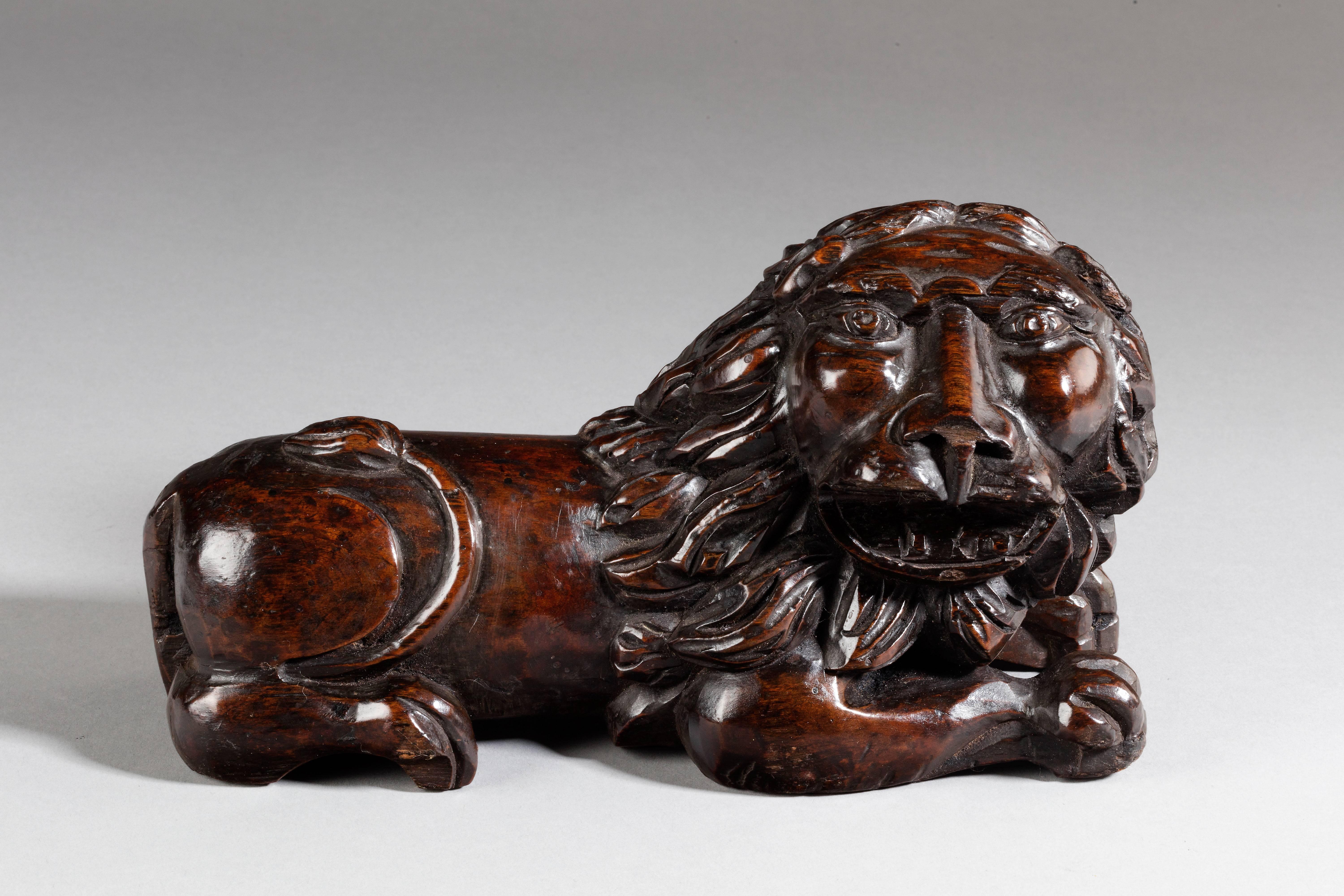 Modelled in the round and with its mouth open and teeth bared, its tail curling up onto its back. 

A comparable wooden lion, dated to the mid-16th Century, and marked as ‘possibly English’, was sold at Christie's in the ‘Syd Levethan: The