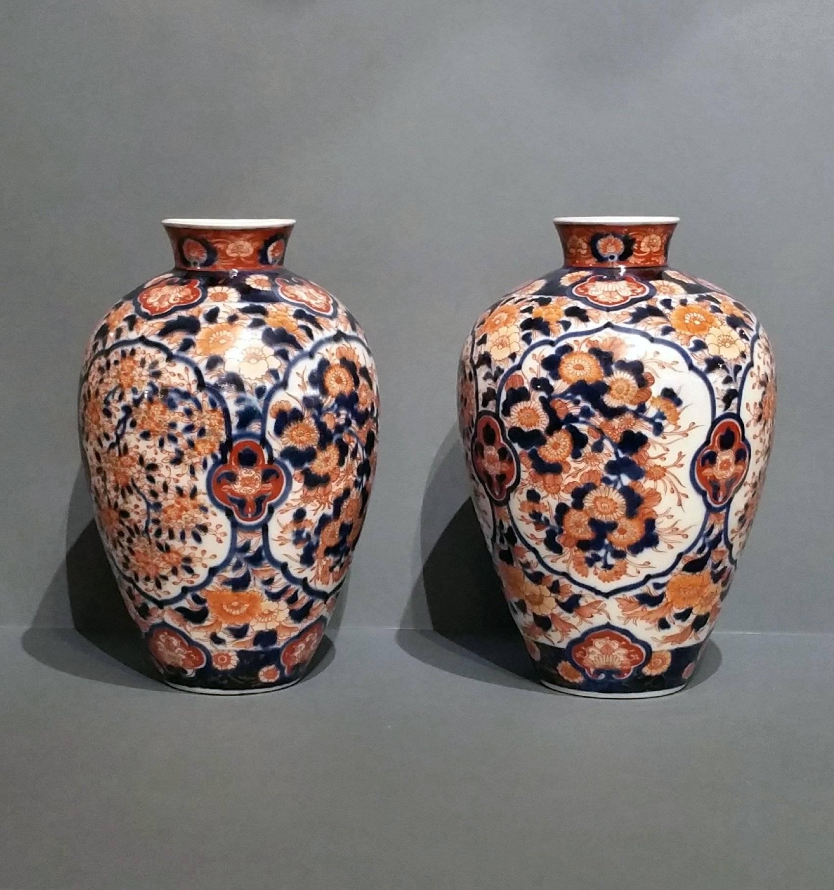 This attractive pair of amphora Imari vases features a profuse chrysanthemum and leaf inspired design in dark blue, orange and white. The vases each measure approximately 7 in – 18 cm in diameter and 10 ½ in – 26.5 cm high.