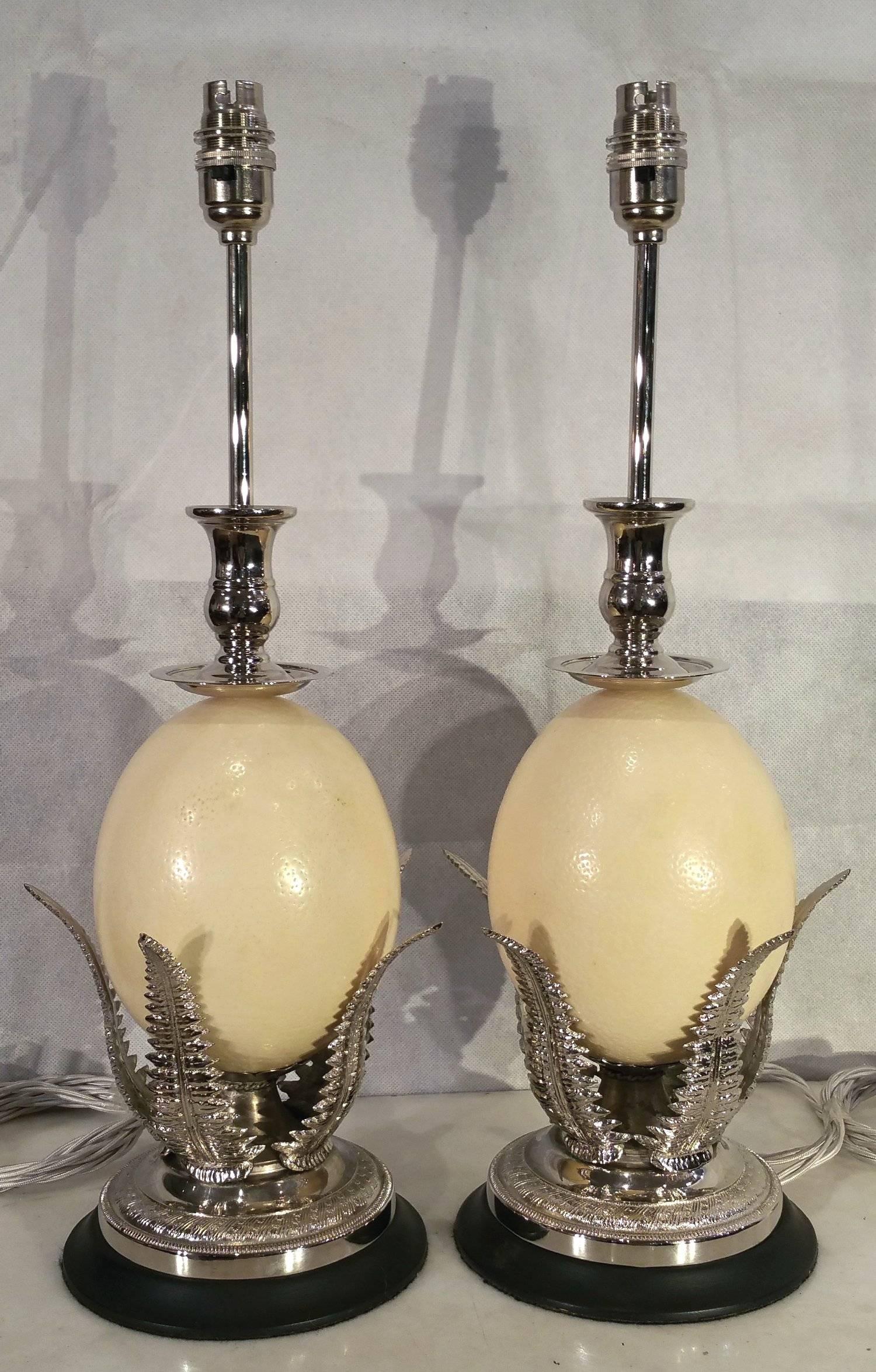 This highly decorative and unusual pair of ostrich egg table lamps has been designed in the Georgian style and rest on a bed of silver plated shaped fern leaves, on a circular base. The lamps feature an elongated neck with a bayonet styled light