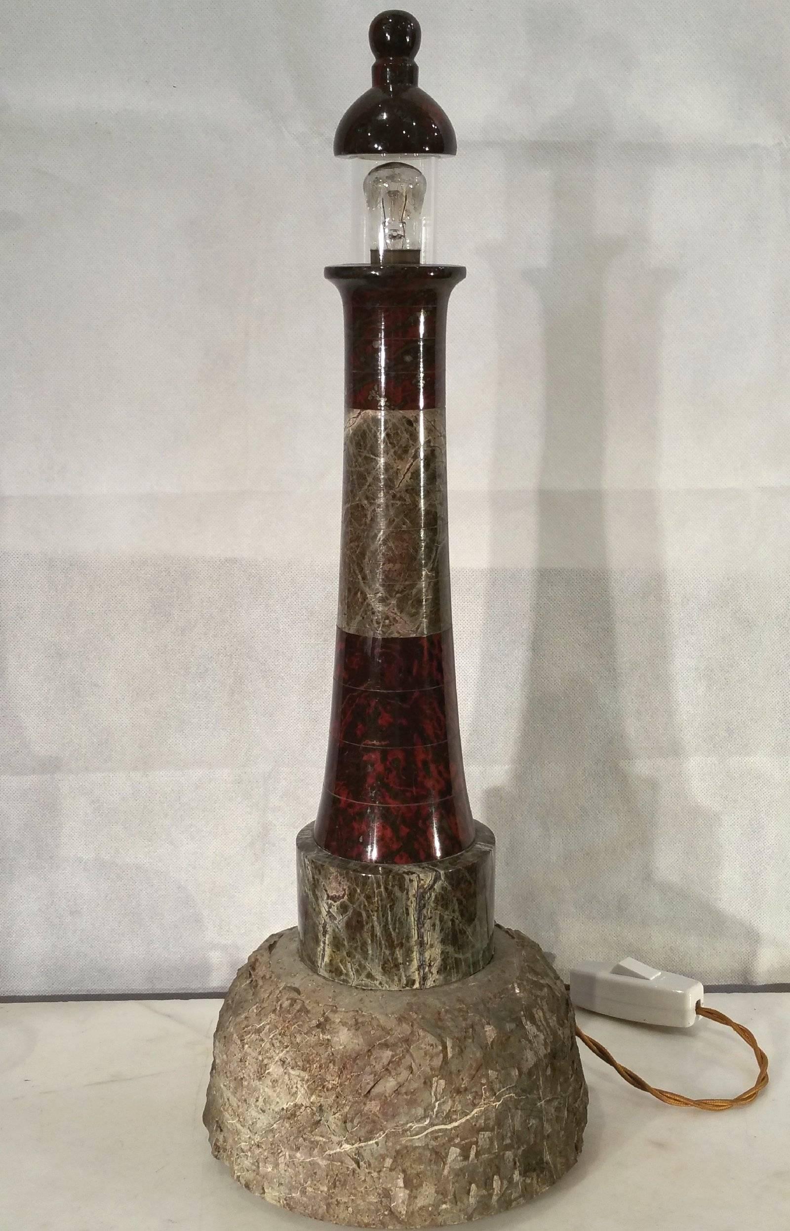 This lovely one of a kind table lamp designed in the shape of a lighthouse, was crafted by an unknown but talented artist, from Cornwall. The building is comprised of joined circular polished pieces of marble, in graduating widths, set on a roughly