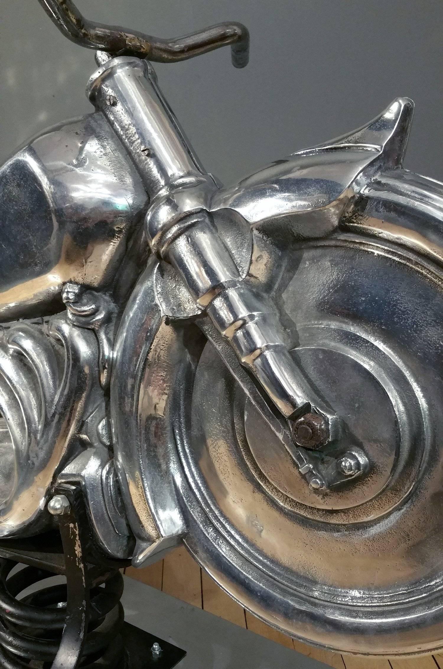 This amazing and rare polished metal miniature toy version Harley Davidson motorcycle is supported on a sturdy metal coil spring support on a polished metal base. This very well designed and high quality motorcycle is perched in an upward poised