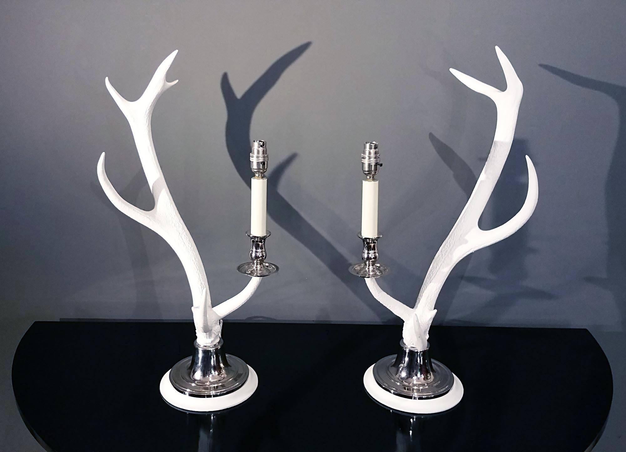 This unusual and highly decorative pair of table lamps are comprised of a rack of naturally shed red deer antlers from Scotland. The antlers have a whitewash finish and are mounted onto a circular nickel-plated base. These lights are a beautiful