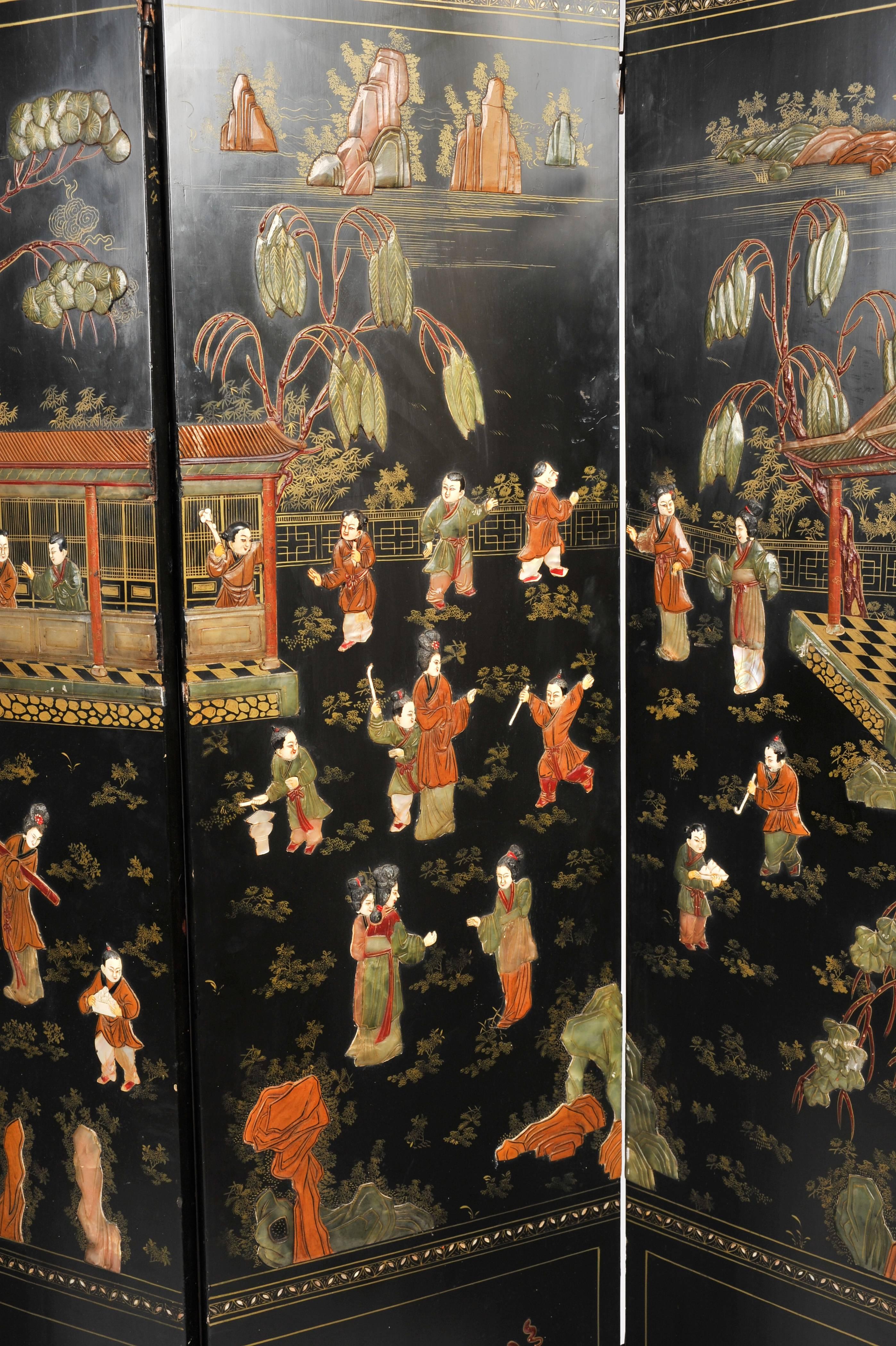 This exquisite and highly ornate 19th century black lacquer Chinese folding screen features 6 panels, each depicting parts of a large outdoor scene of various men and women performing various tasks around a large central house. The design and all