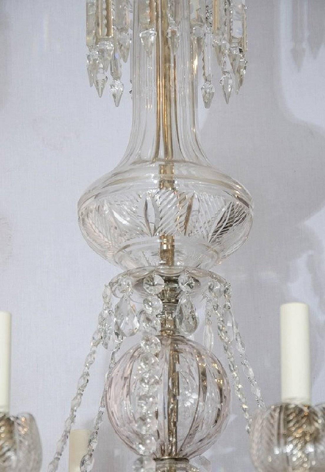 This stunning large Regency style chandelier features handmade glass crystals on two tiers and candle style light fittings set inside glass ‘cupped’ shaped holders with leaf detail decoration. The top tier has 6 arms and the bottom tier has 6, on an