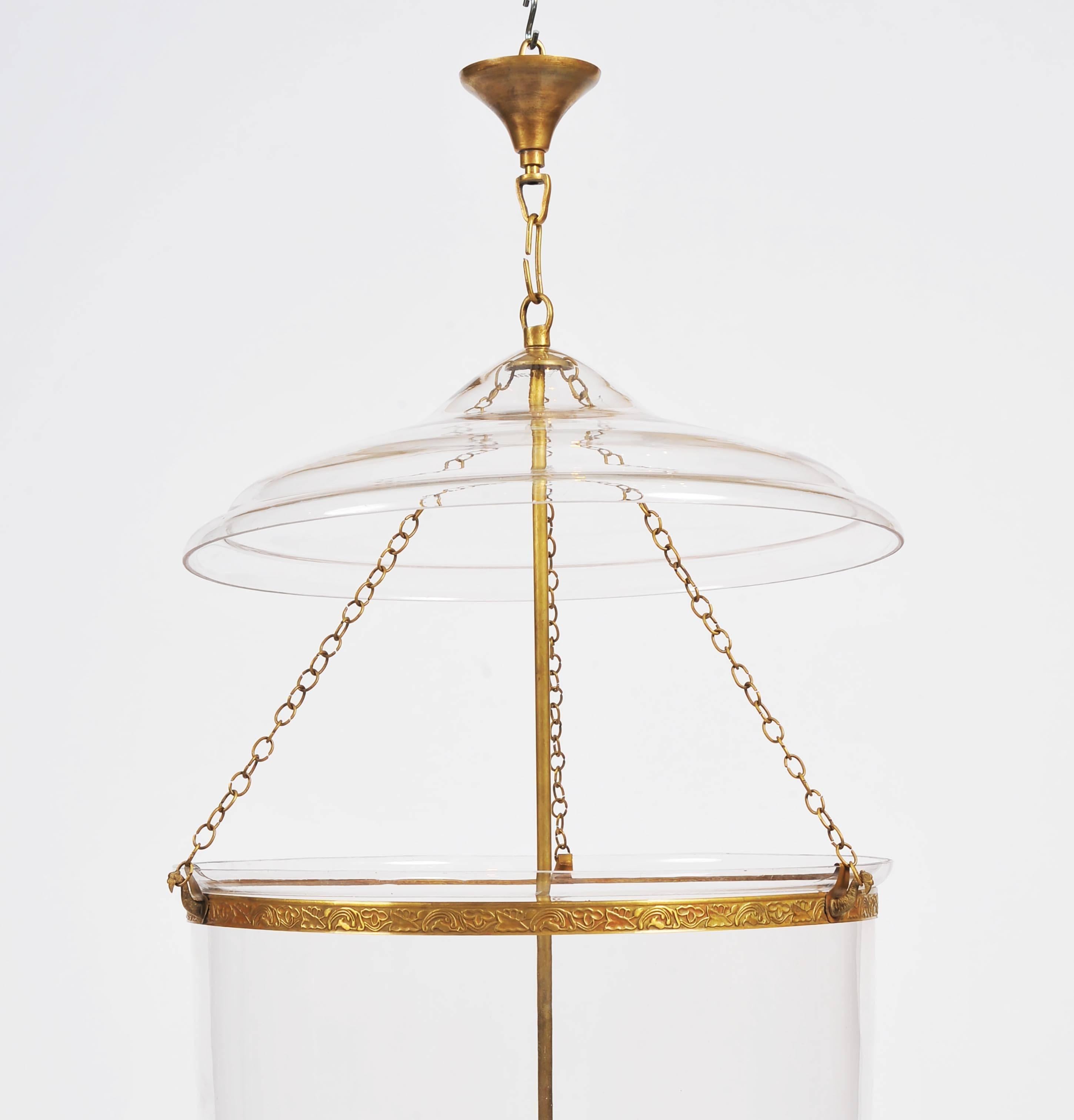 This elegant and well-proportioned handmade glass storm lantern features a simple yet elegant clear blown glass design with polished brass hardware. The lantern has a separate top plate and features an internal 4 light fitting. The light measures 14