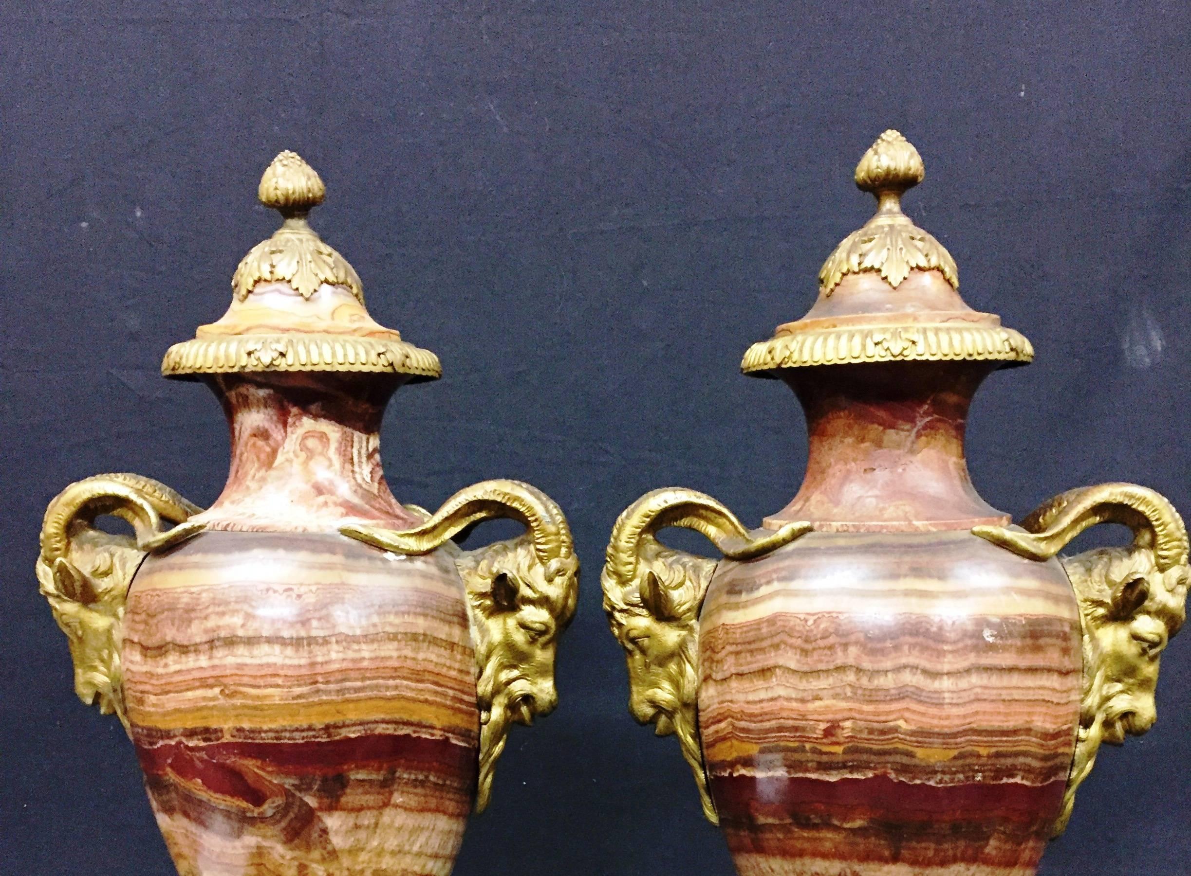 A very impressive pair of French 19th century marble and gilded ormolu lidded urns. Each with classical ram’s head mounts.