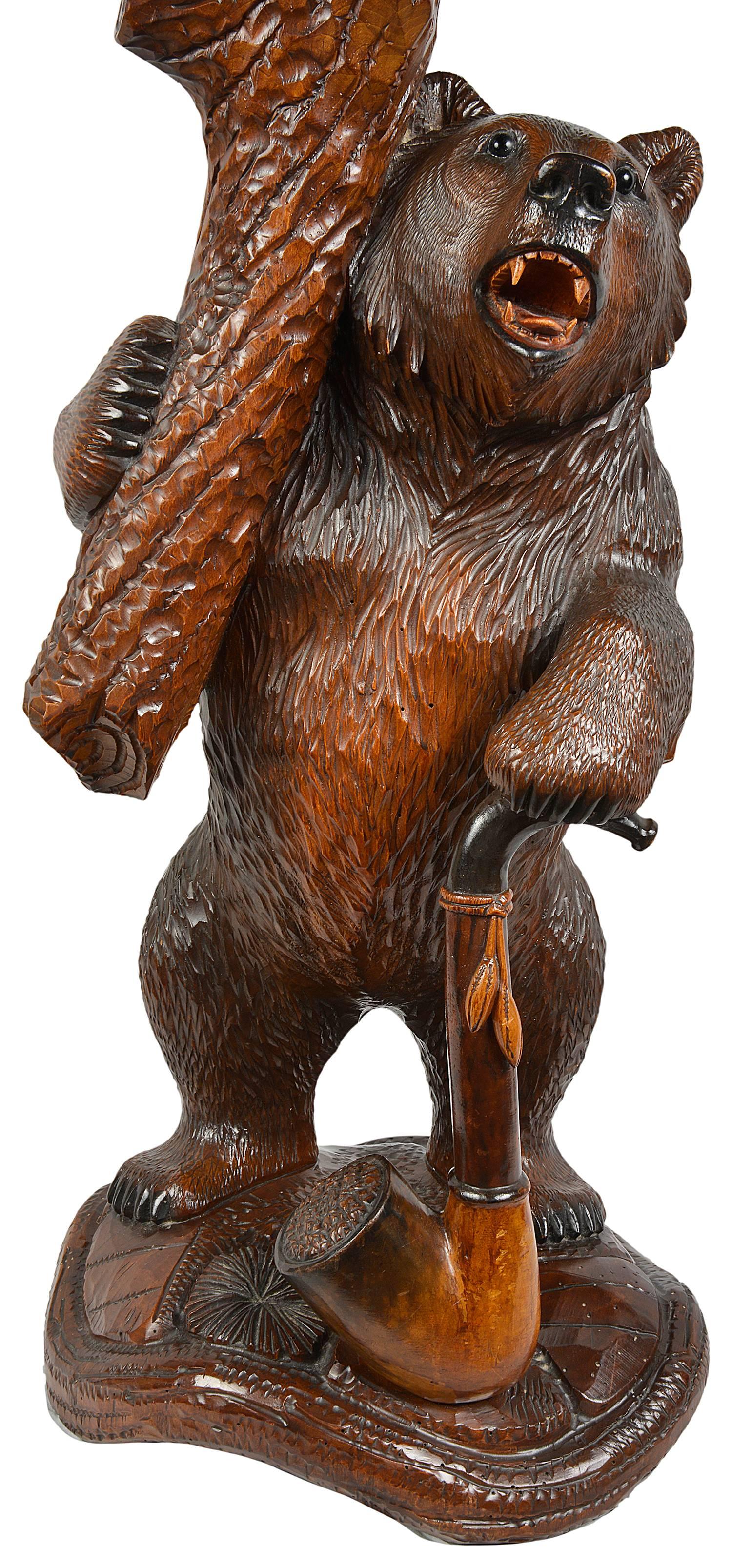 A very good quality 19th century black forest carved wood smokers stand. Having two lidded compartments with two carved bears on their backs, a cigar cutter and two brass ash trays. The beautifully carved standing bear supporting the table and