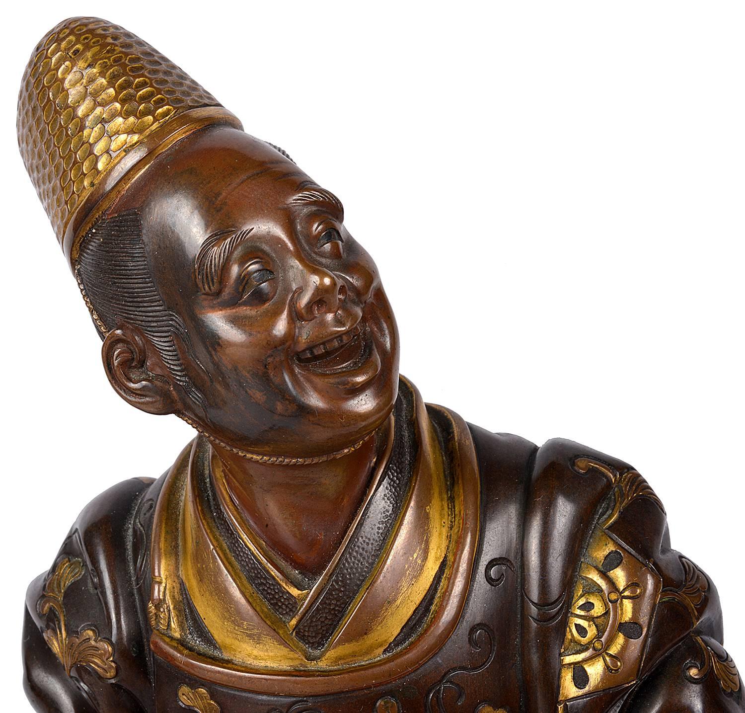 A very good quality Japanese Meiji period (1868-1912) bronze figure of a gentlemen holding an umbrella. Having gilded highlighted decoration and raised on a hardwood stand.
Signed; Miyao.