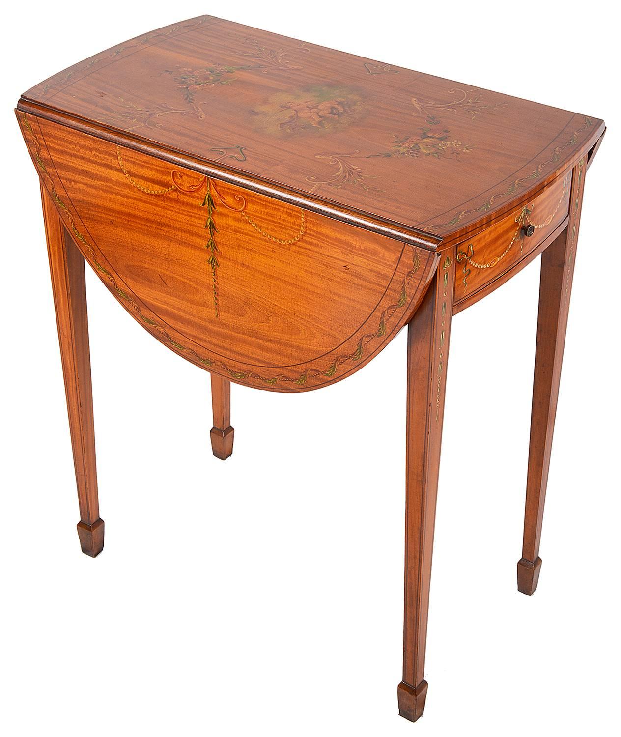 An Edwardian period satinwood Pembroke table, having classical painted decoration, a frieze drawer, drop leaves and raised on square tapering legs.