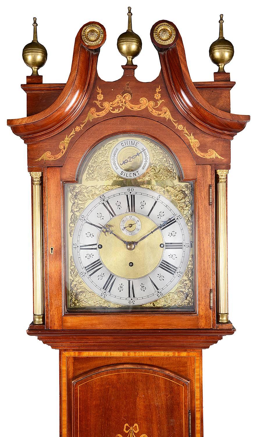 A good quality Edwardian period mahogany longcase clock with a Westminster and Whittington chime on the hour. Having an arched brass dial face, a swan neck pediment to the hood with brass finials and boxwood inlaid decoration to the case.