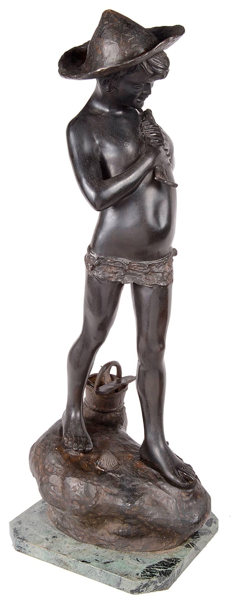 A good quality late 19th century bronze statue of a young boy fishing. Standing on a rocky out crop with a crab at his feet. Holding a fish and wearing a wide brimmed hat.