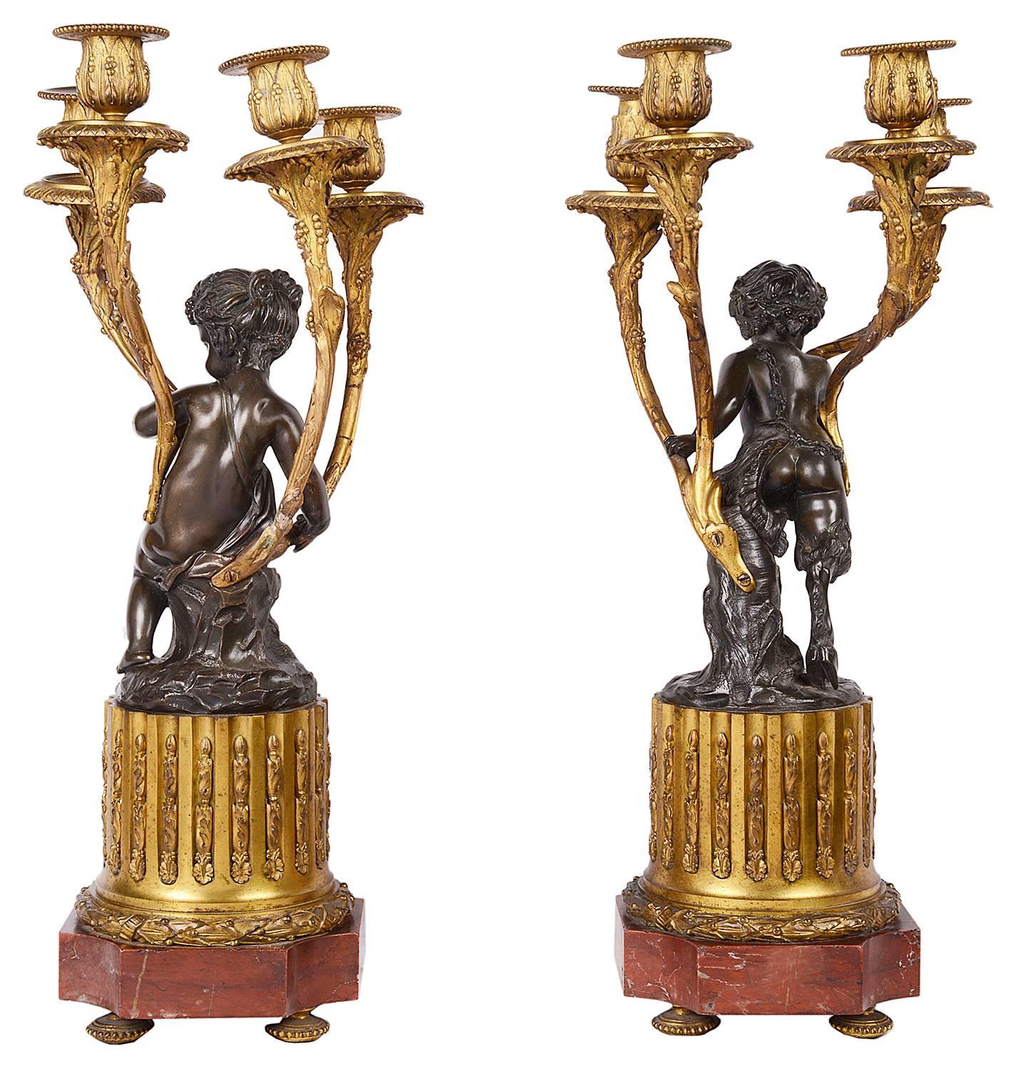A good quality large pair of French 19th century bronze, ormolu and rouge marble candelabra. Each having a cherub holding a four branch candelabra with foliate decoration, raised on stop fluted plinths and rouge marble bases.