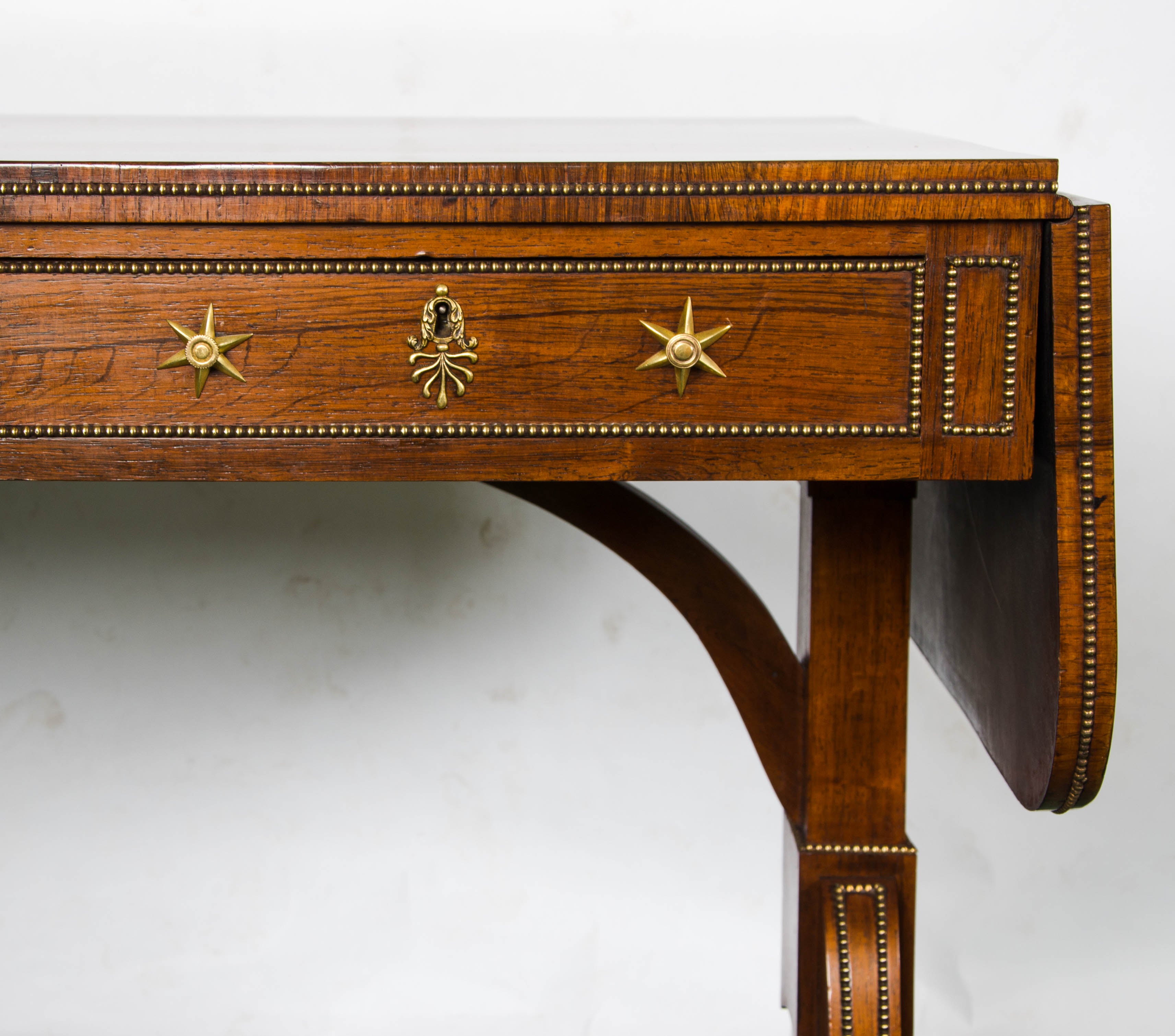 A rare pair of Regency period end support rosewood sofa tables, having two mahogany lined frieze drawers, dummy drawers to the reverse. End supports, beeded ormolu mounts and the original brass castors.