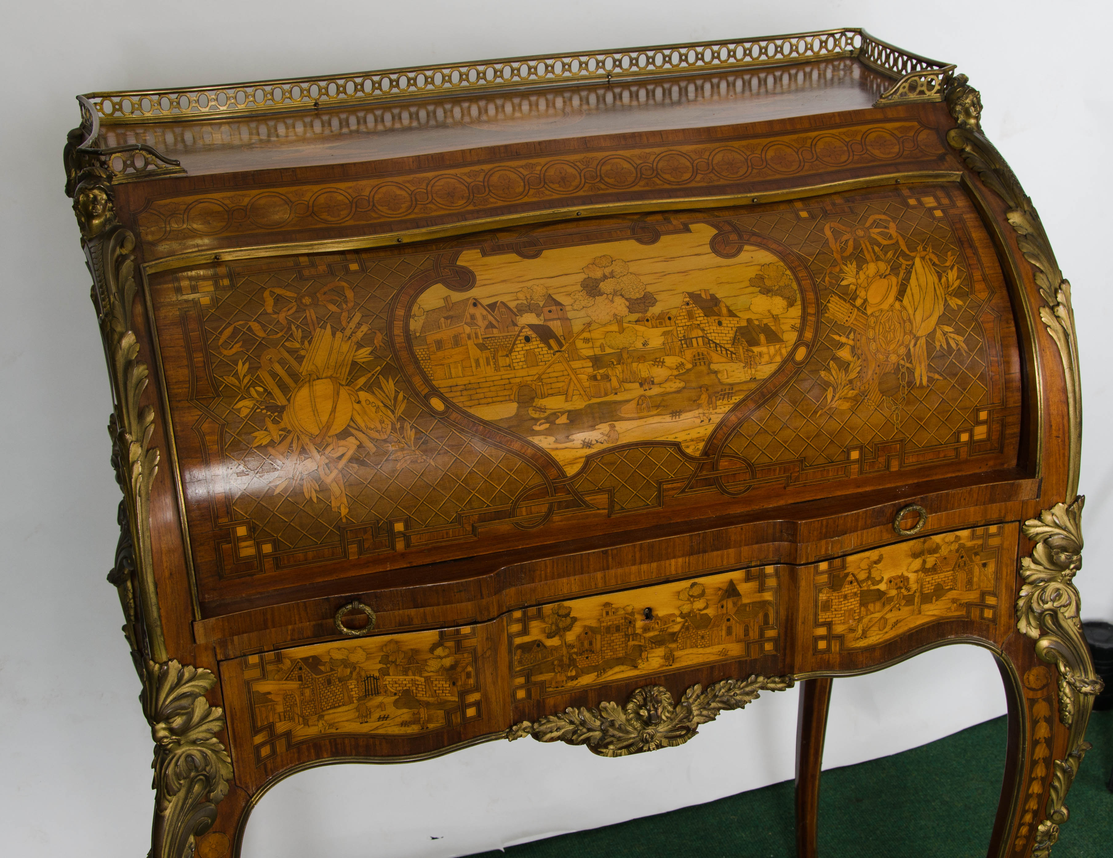 A fine quality 19th Century Louis XV style Marquetry inlaid bureau de dame, having wonderfully detailed scenes to the drawer fronts and cylinder, the sides and reverse having foliate decoration surrounding urns and musical instruments. A three
