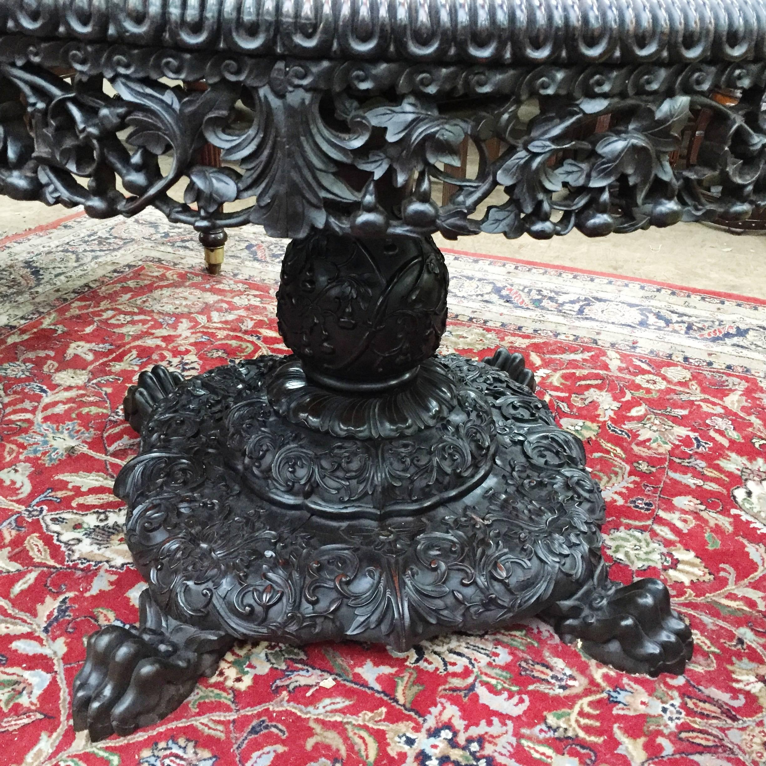 A very good quality 19th century Chinese hardwood centre table, with an inset marble top, carved decoration to the frieze, central column and base, raised on carved claw feet.