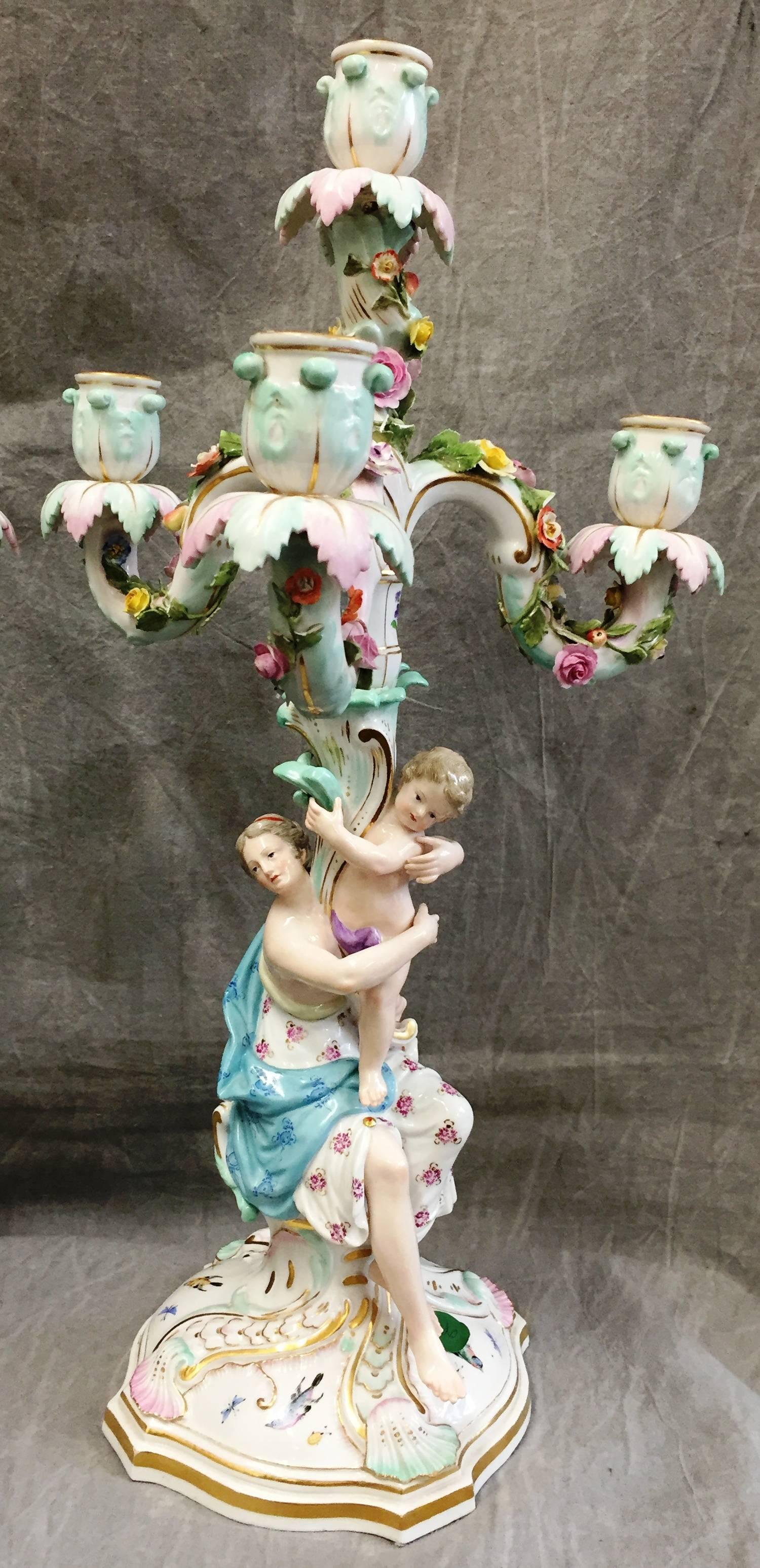 A very good quality pair of 19th Century Meissen porcelain five branch candelabra, having infants resting on the laps classical male and female figures.