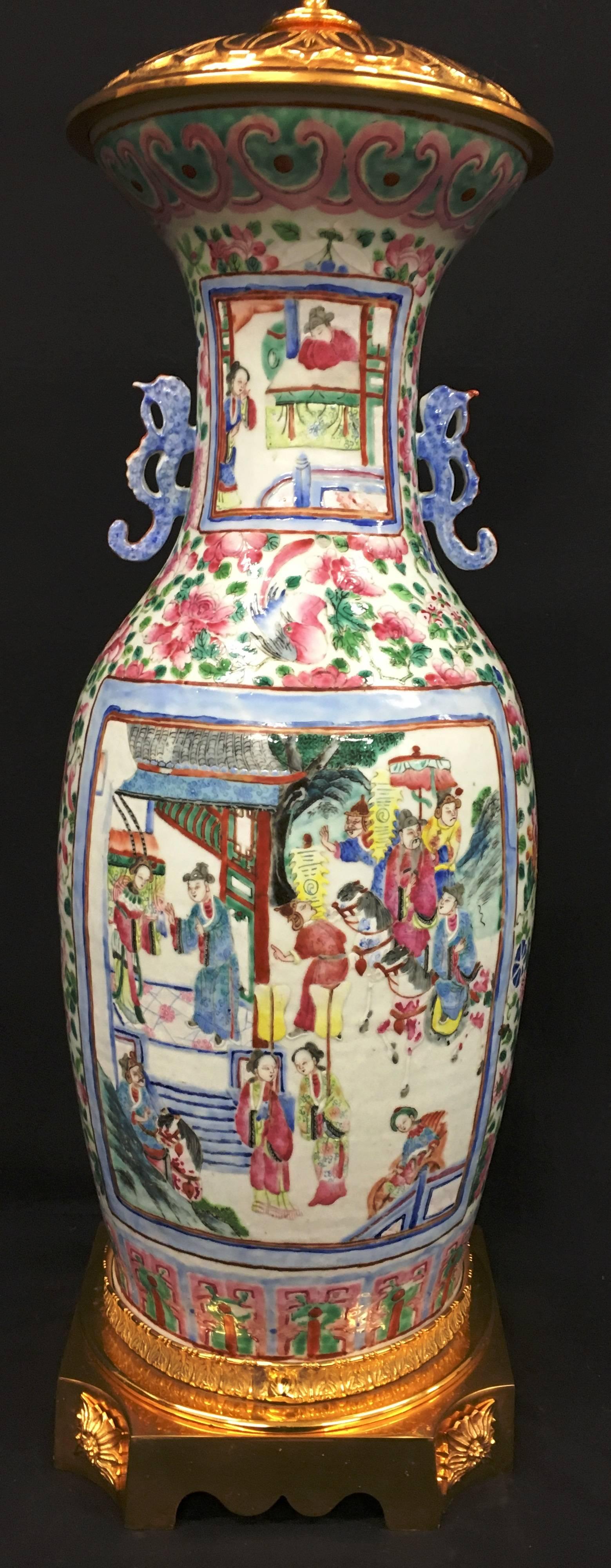 Un impressionnant vase ou lampe de la Famille rose chinoise du 19ème siècle. Les panneaux sont joliment peints et représentent des mortels dans un temple et des jardins, dans un cadre floral, avec des montures en bronze doré.