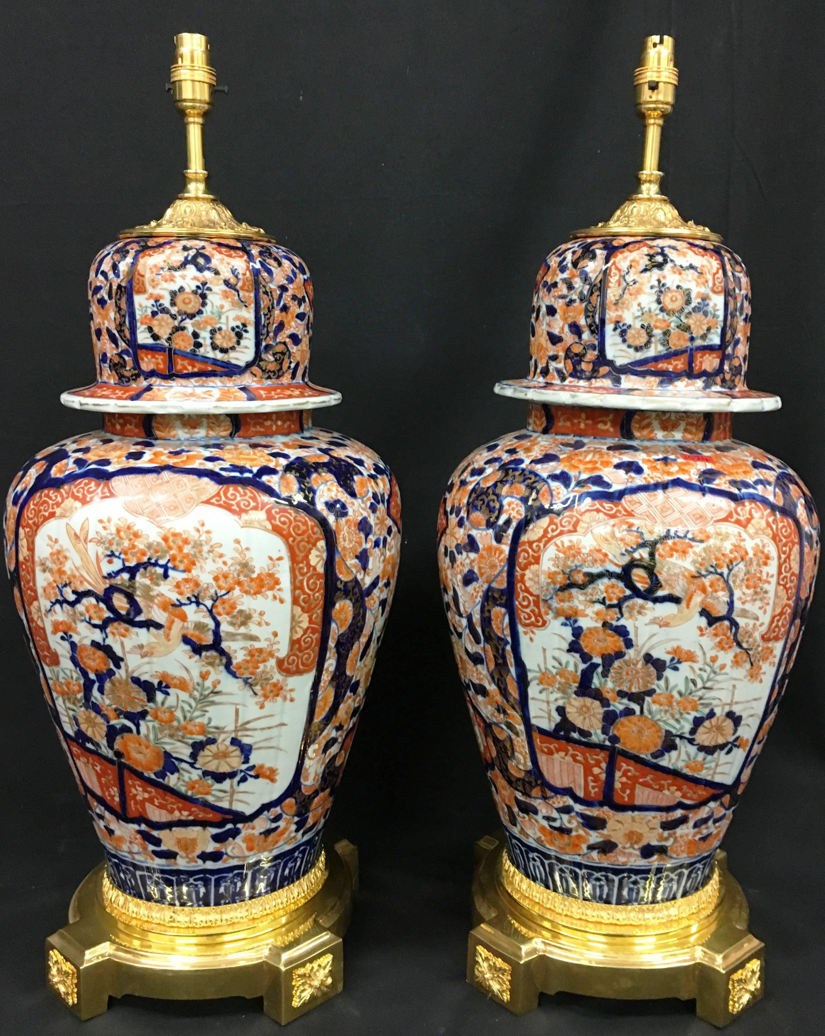 A very impressive pair of Japanese lidded Imari vases/lamps. Each with painted inset panels depicting flowers, trees and exotic birds. Mounted with gilded ormolu tops and bases.