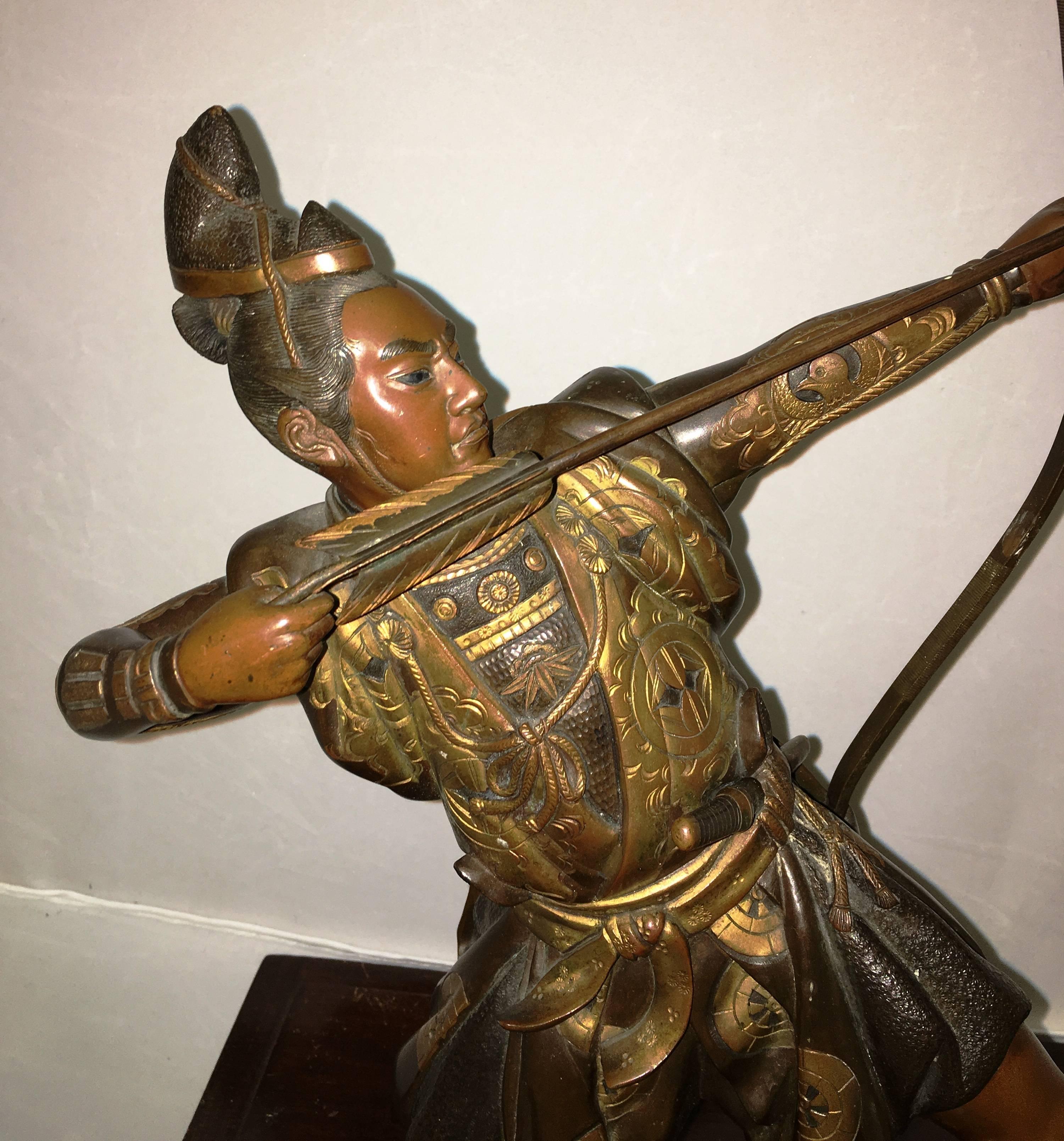 A good quality late 19th century, Japanese bronze of an Archer, having gilded decoration and mounted on carved oriental hardwood base.
  