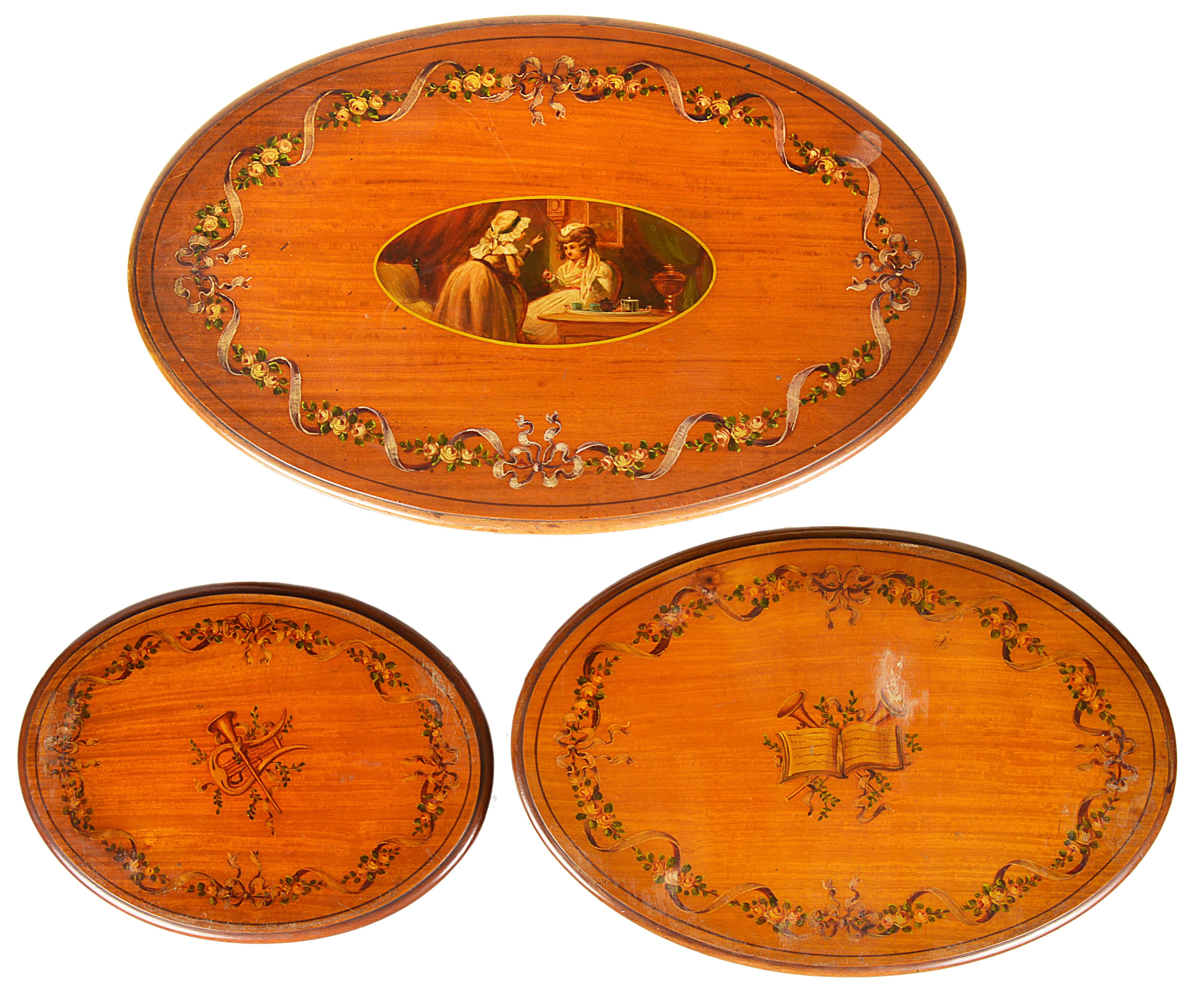 A good quality nest of three Sheraton Revival oval satinwood tables, each with hand-painted classical decoration.