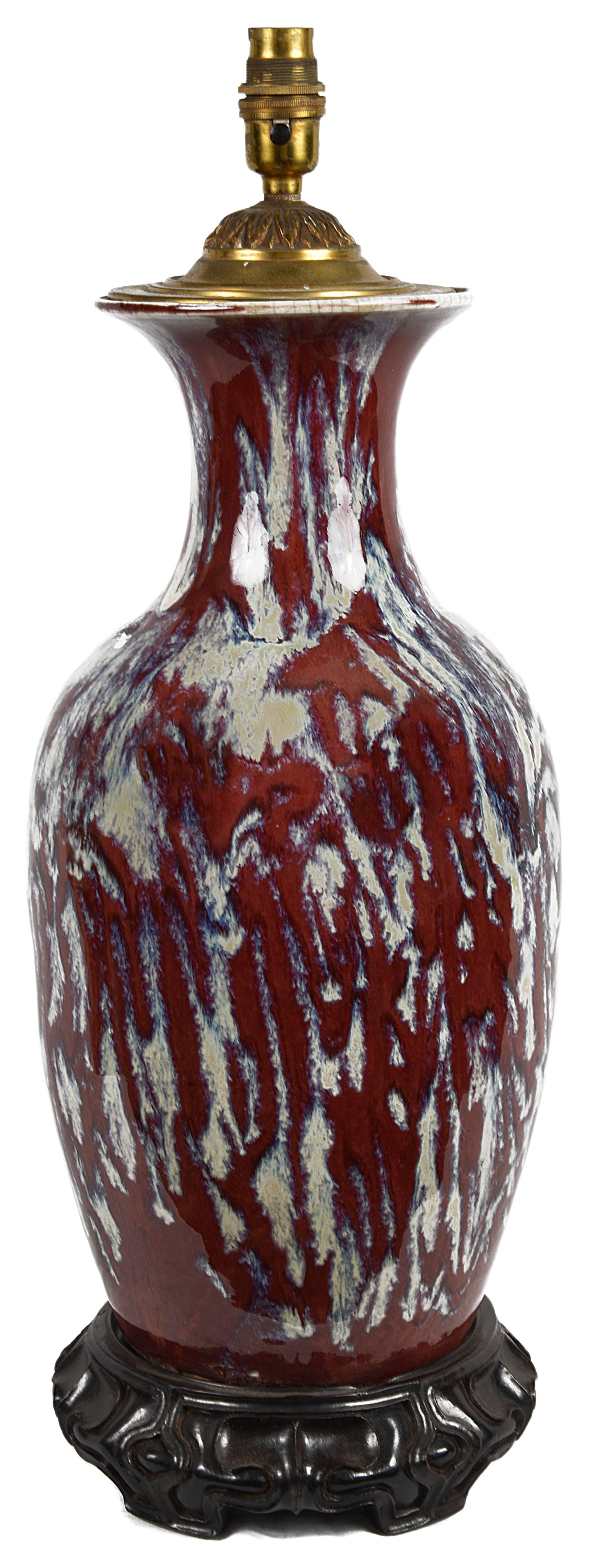 Vase balustre très décoratif en forme de sang de bœuf chinois du 19e siècle, converti en lampe. Monté sur un socle en bois dur sculpté.
