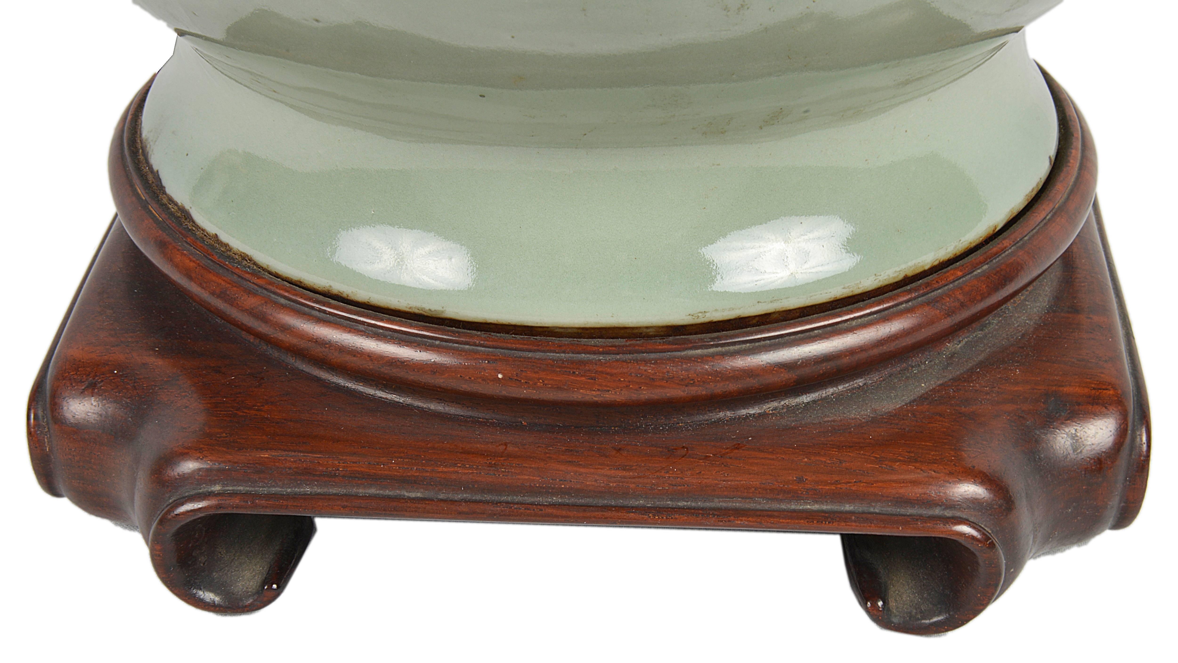 A very stylish 19th century, Chinese Celadon porcelain bulbous shape vase, having mythical creator handles with rings. Mounted on a Chinese hardwood stand.