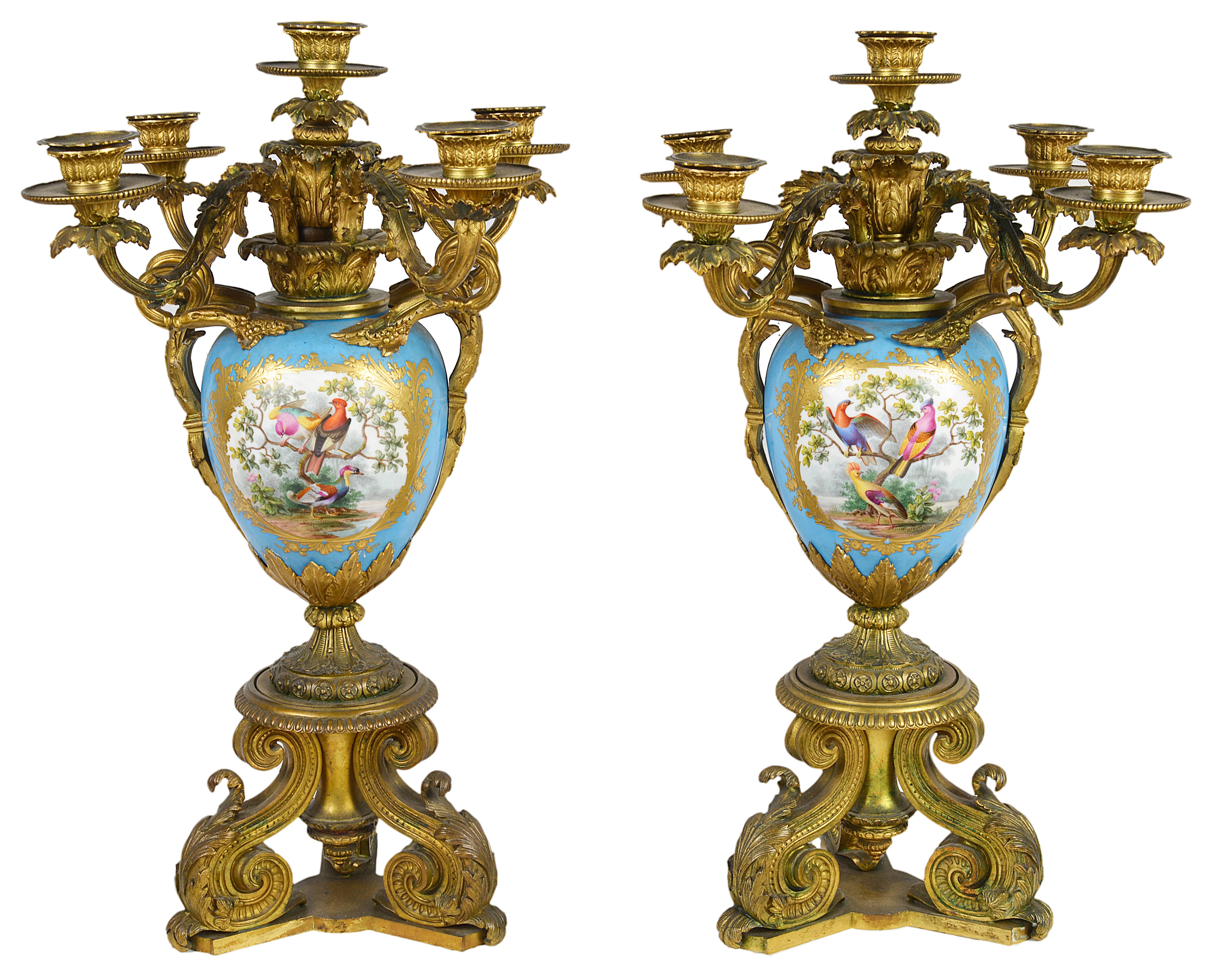 A very impressive pair of French 19th century sevres porcelain and gilded ormolu candelabra. Each candelabra having five branches with scrolling leaf decoration. The turquoise porcelain vases having hand-painted panels of exotic birds with gilded