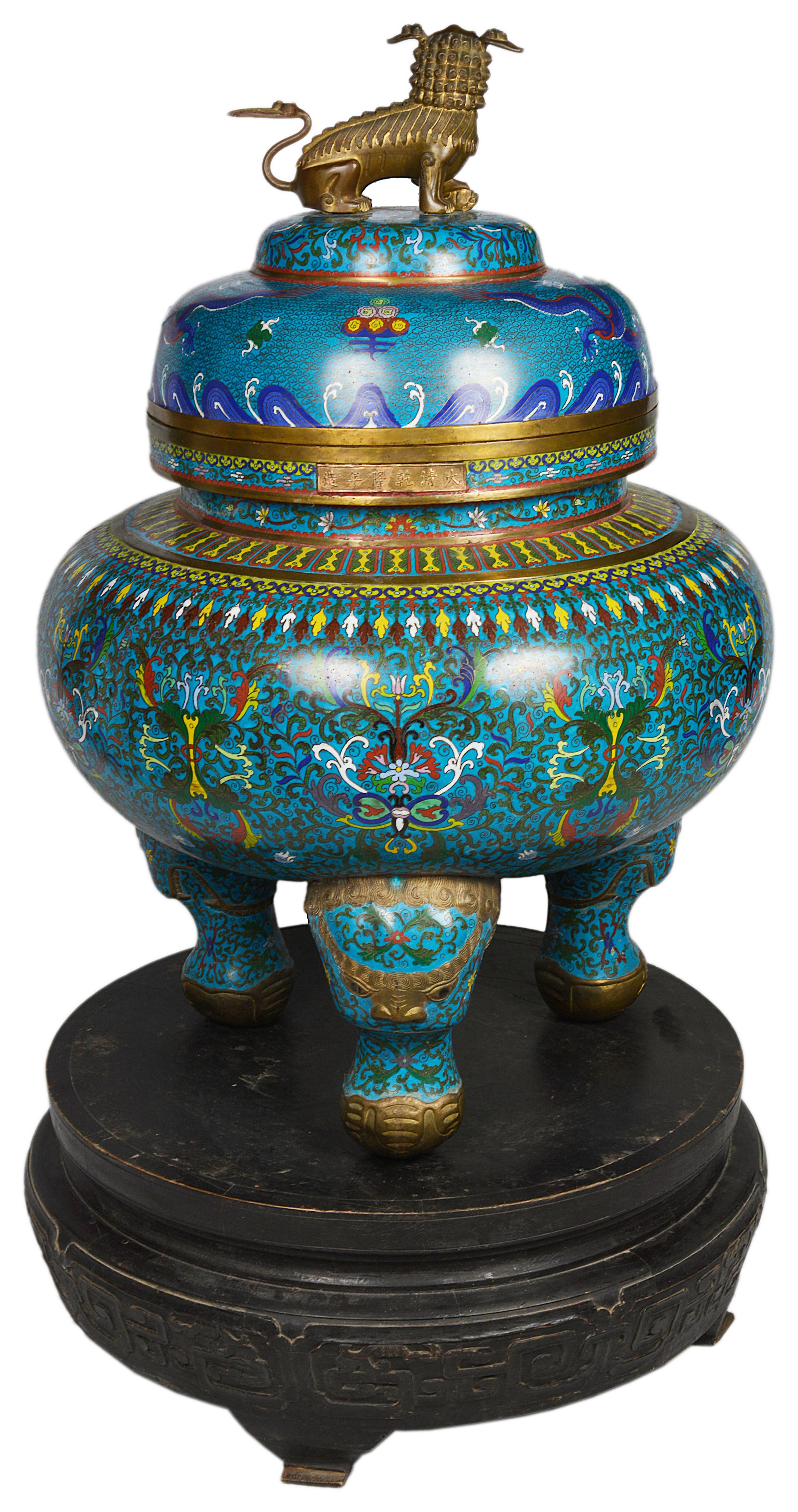 A very impressive Chinese late 19th century cloisonné lidded Koro. Having a mythical dog of faux as a finial. The cloisonné enamel depicting dragons and classical symbols, set up on a carved ebonized stand.
